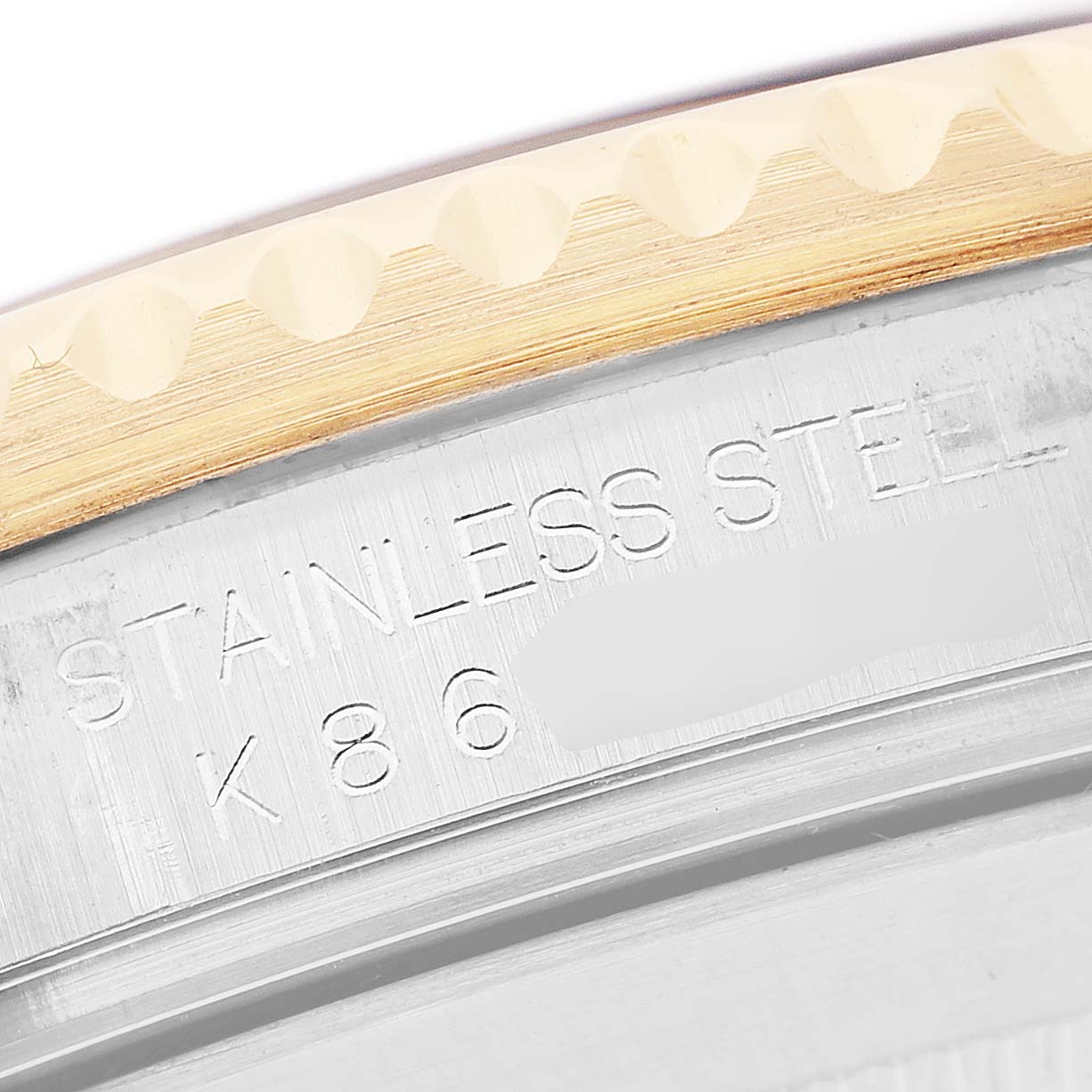 The image shows a close-up of the bezel and engraved case edge of a Rolex Submariner 16613 Men's Steel and Gold (two tone) Blue Dial, highlighting the stainless steel marking.