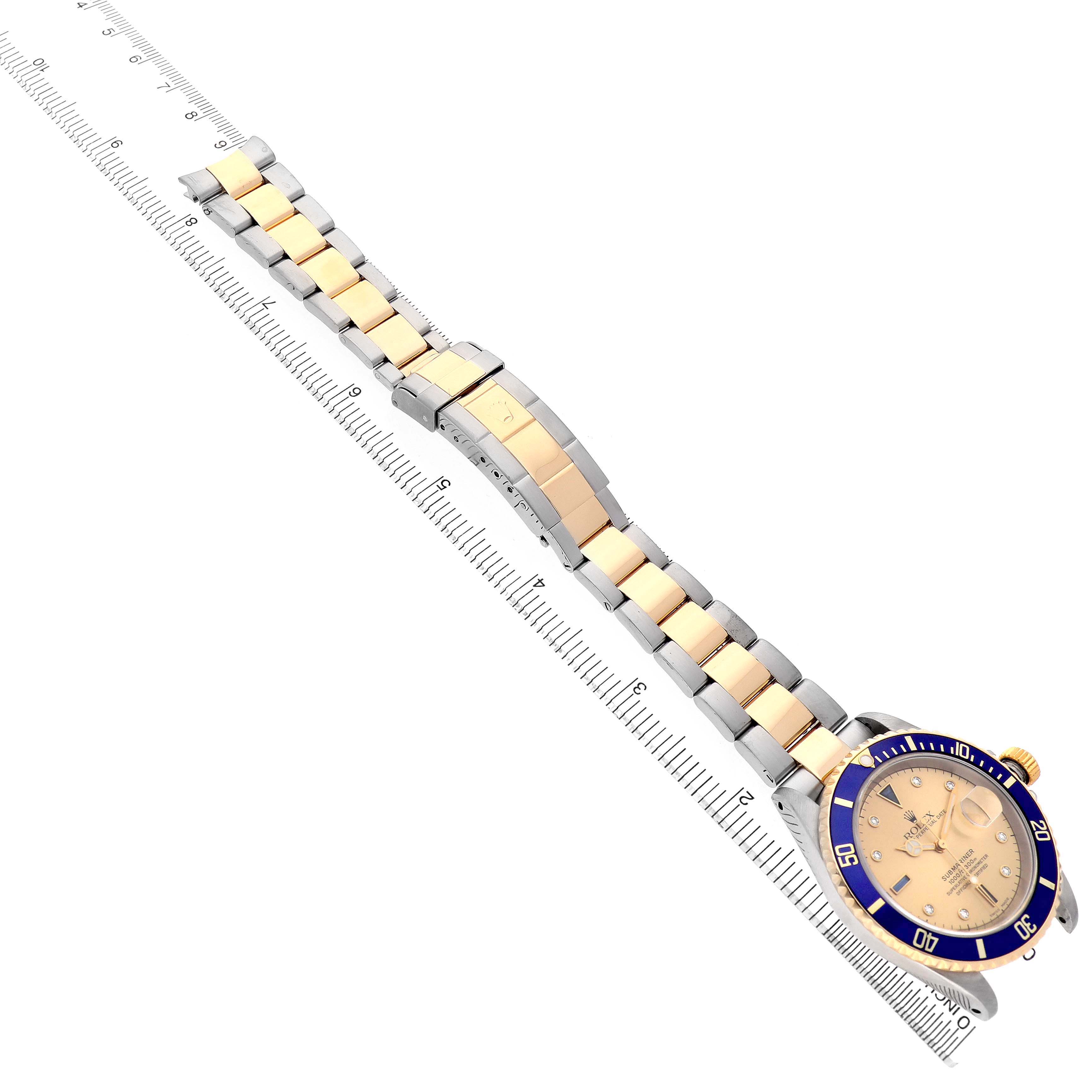 The image shows a Rolex Submariner 16613 Men's Steel and Gold (two tone) Blue Dial watch at an angle, featuring the full bracelet, clasp, and bezel with ruler measurements.