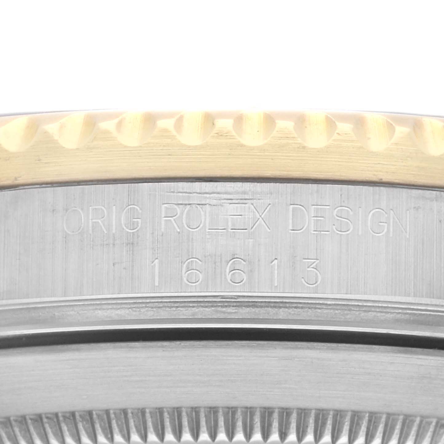 This close-up image of a Rolex Submariner 16613 Men's Steel and Gold (two tone) Grey Dial 16613 Men's Steel and Gold (two tone) Grey Dial watch shows the engraved model number "16613" and part of the bezel.