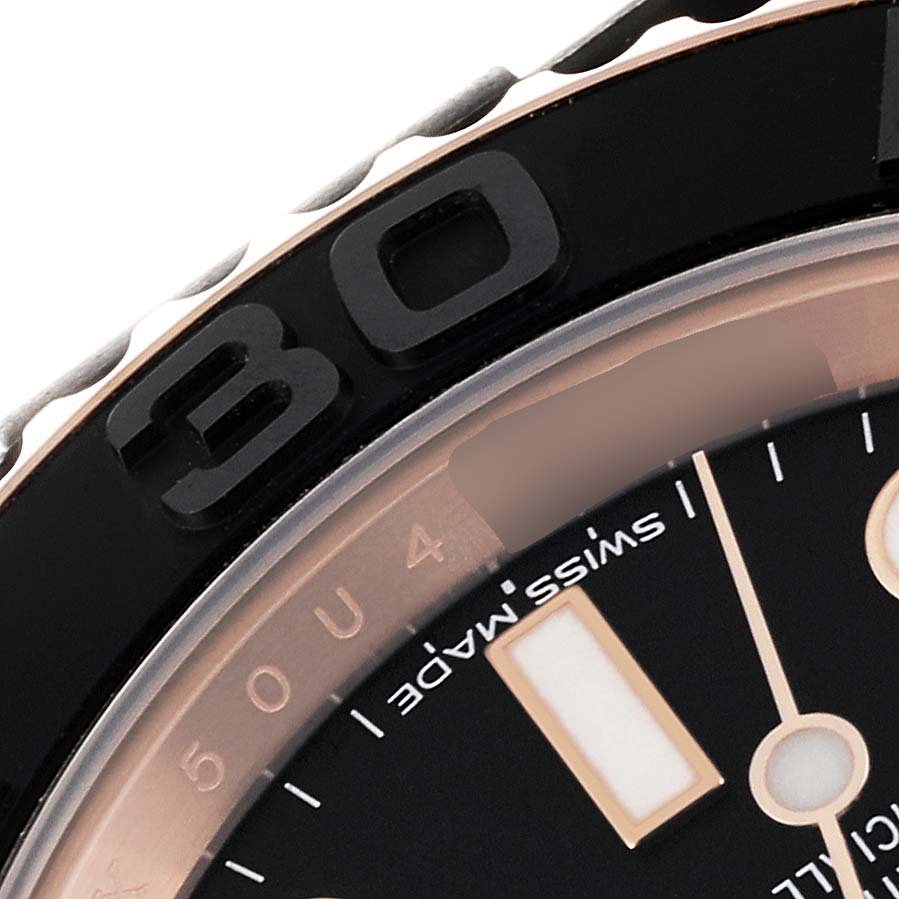 The image shows a close-up of the bezel and part of the dial of the Rolex Yacht-Master 116655 Men's Rose Gold Black Dial 116655 Men's Rose Gold Black Dial watch.