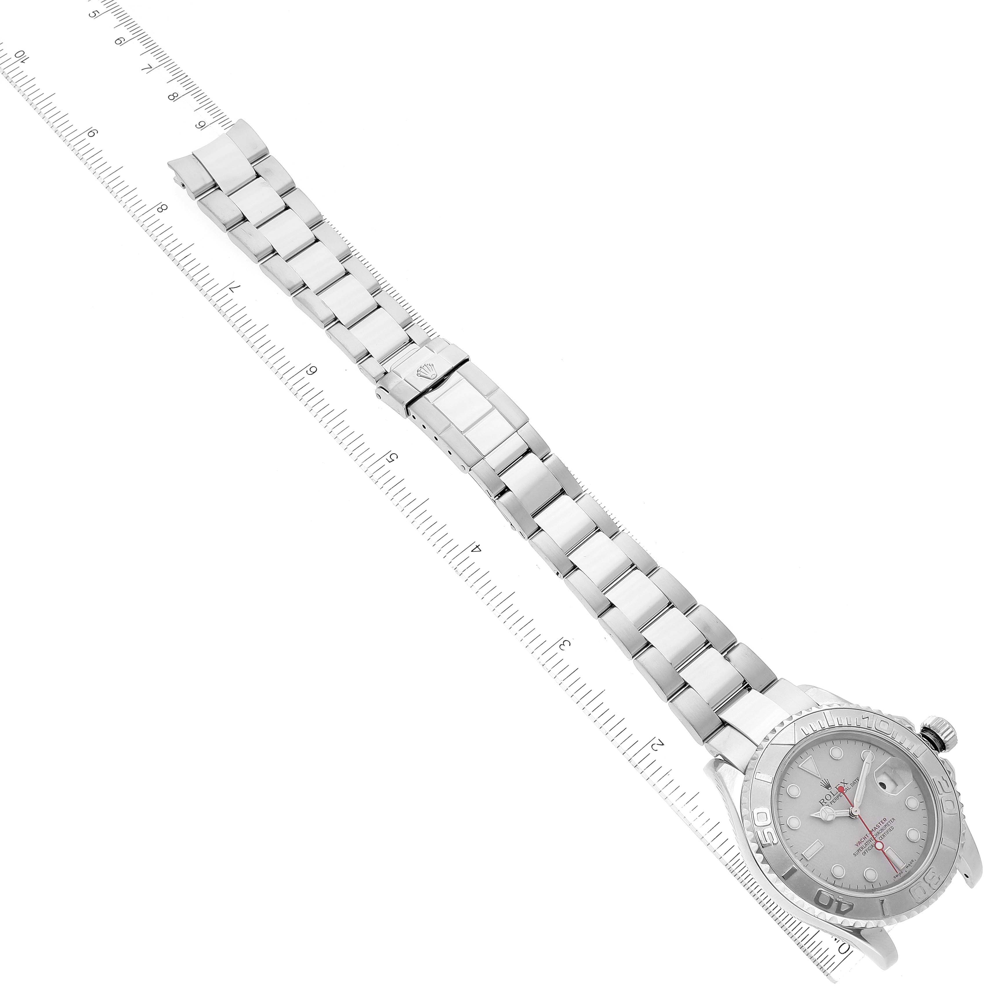 The image shows a side view of a Rolex Yacht-Master 16622 Men
s Stainless Steel Silver Dial 16622 Men
s Stainless Steel Silver Dial watch lying flat with its clasped metal bracelet extended alongside a ruler.