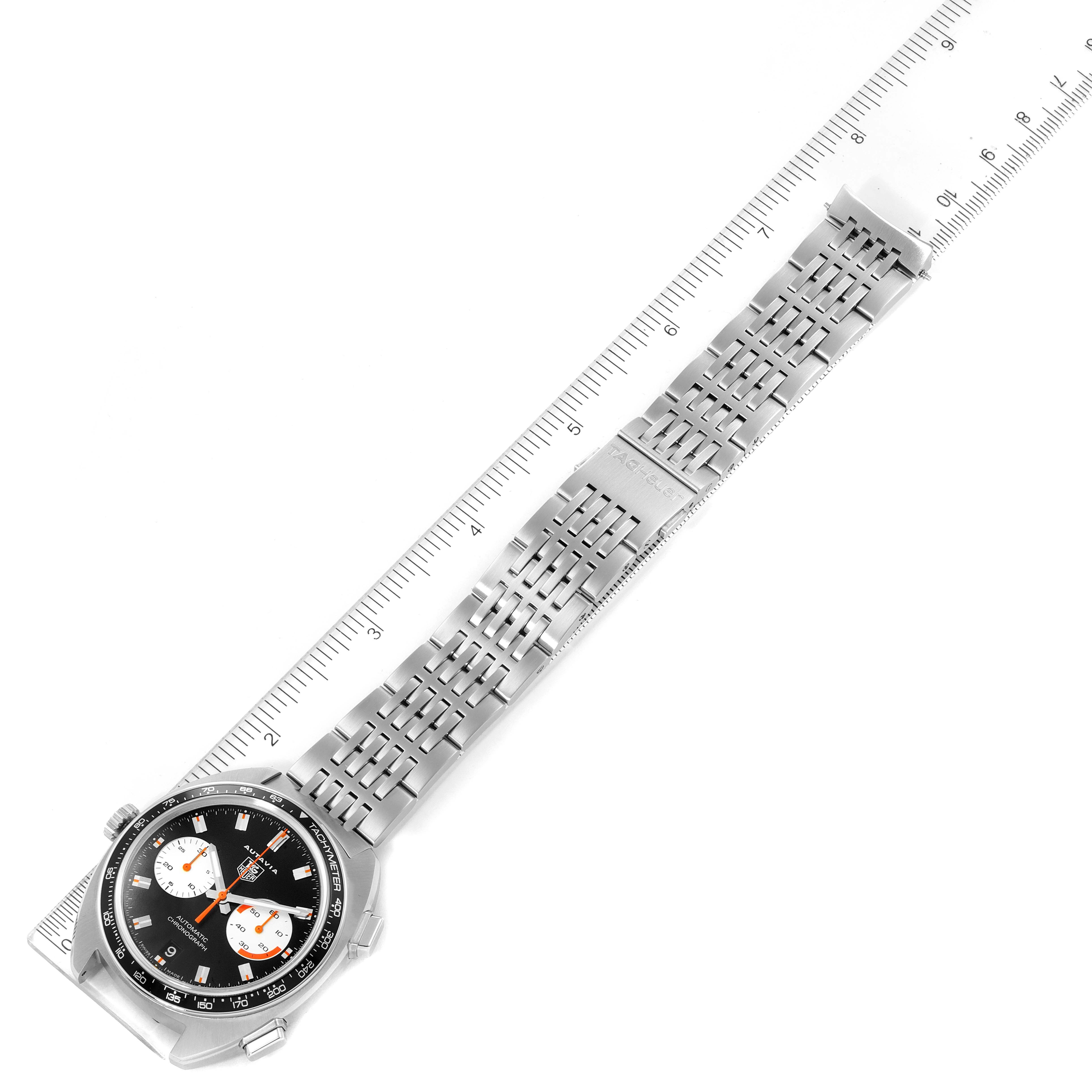 The image shows a top view of a Tag Heuer Autavia CY2111 Men's Stainless Steel Black Dial CY2111 Men's Stainless Steel Black Dial watch, highlighting the face, bezel, and bracelet against a ruler.