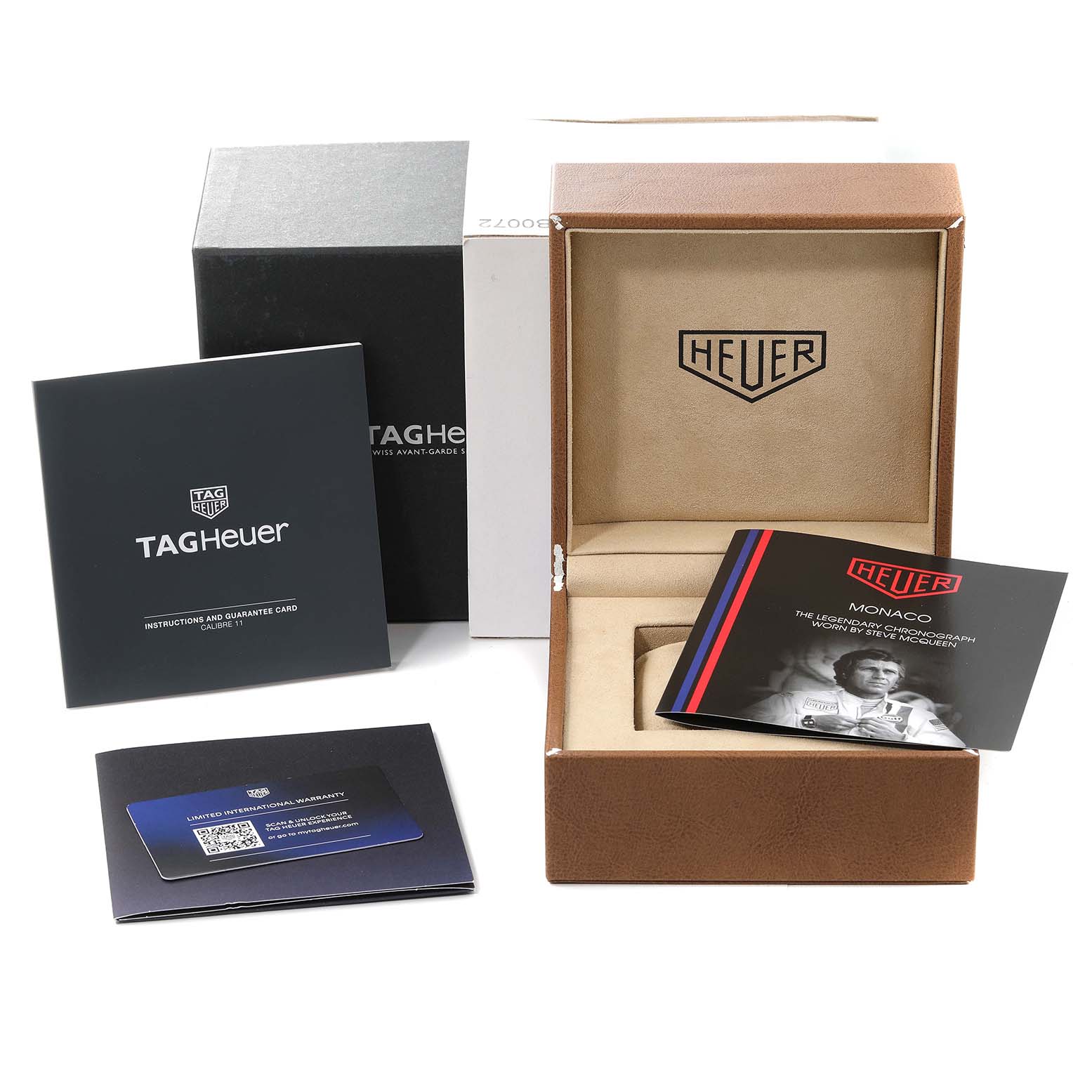 The image shows the packaging and accessories of a Monaco model by Tag Heuer, including the box, manuals, and guarantee card.