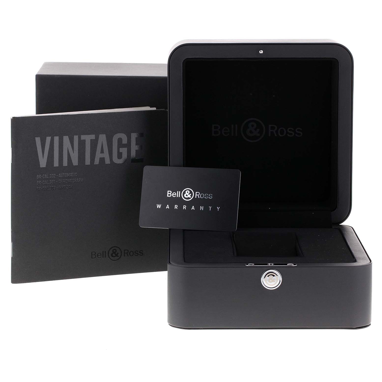 The image shows the packaging and accessories of the Bell & Ross Heritage BRV292-BU-G-ST/SCA Men's Stainless Steel Blue Dial BRV292-BU-G-ST/SCA Men's Stainless Steel Blue Dial model, including a box, warranty card, and manual.