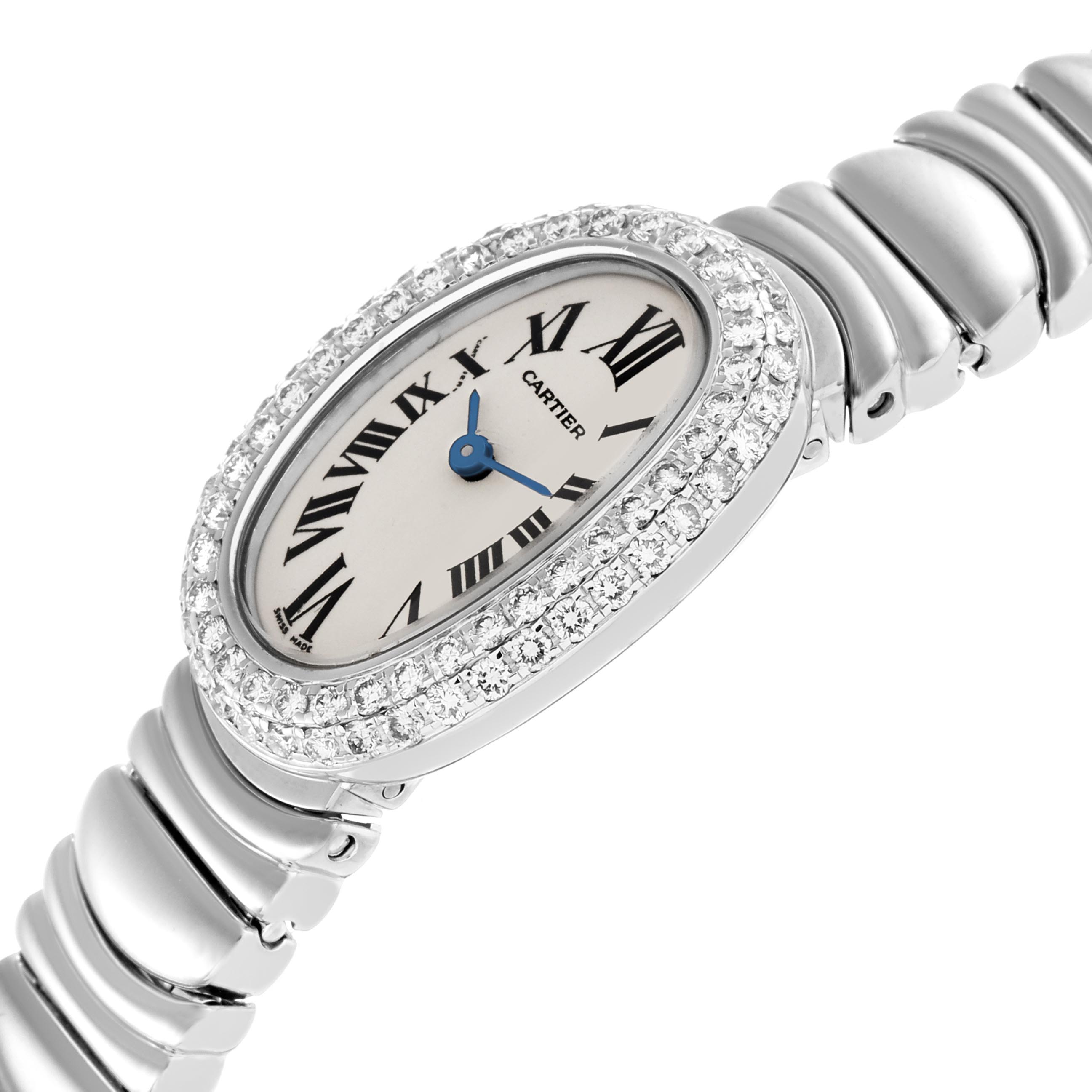 The Cartier Baignoire WB095W2 Women's White Gold Silver Dial WB095W2 Women's White Gold Silver Dial watch is shown at an angle displaying its oval face, diamond bezel, blue hands, and metallic bracelet.
