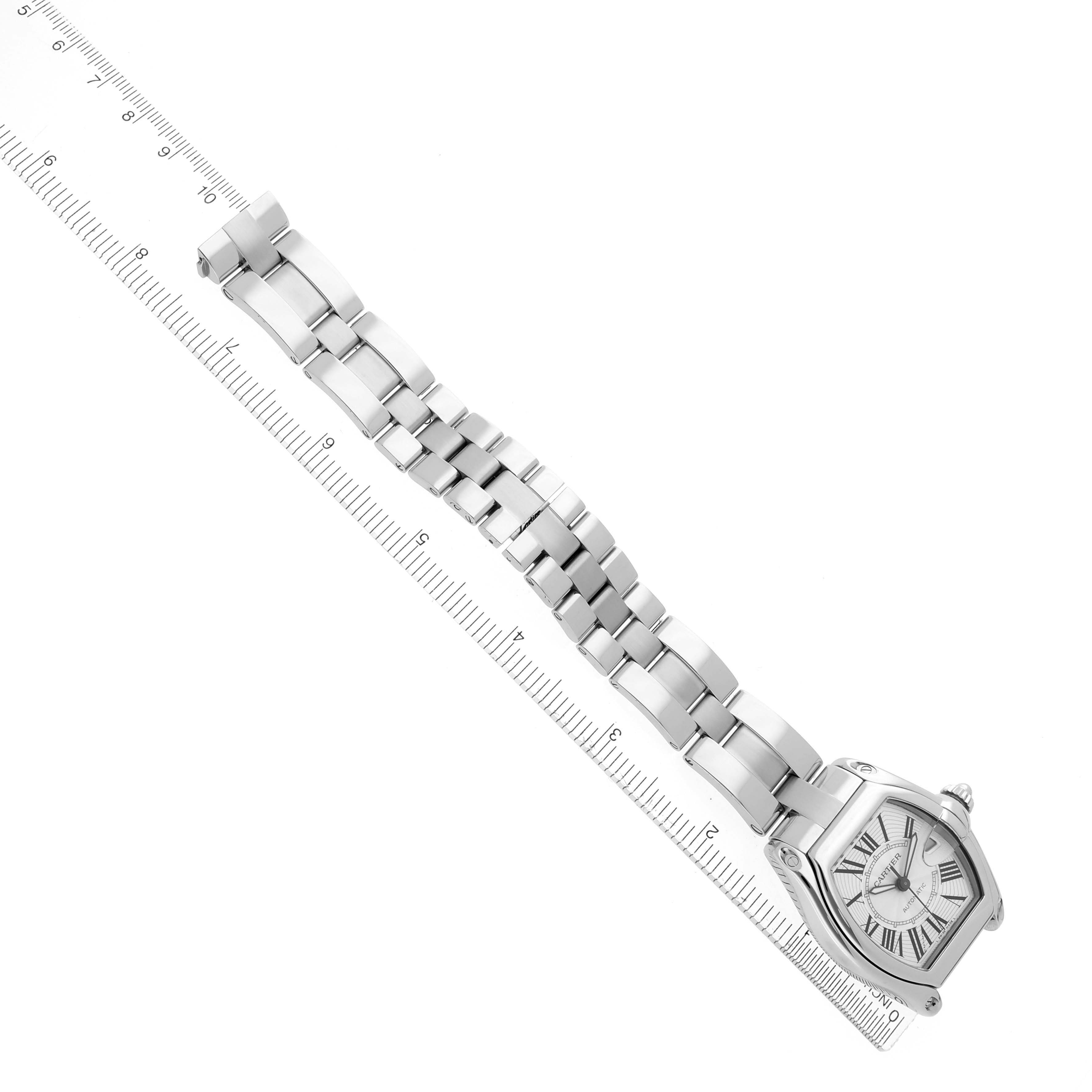 The Cartier Roadster W62025V3 Men's Stainless Steel Silver Dial W62025V3 Men's Stainless Steel Silver Dial watch is shown from a top-down angle, displaying its face and bracelet aligned with a ruler.
