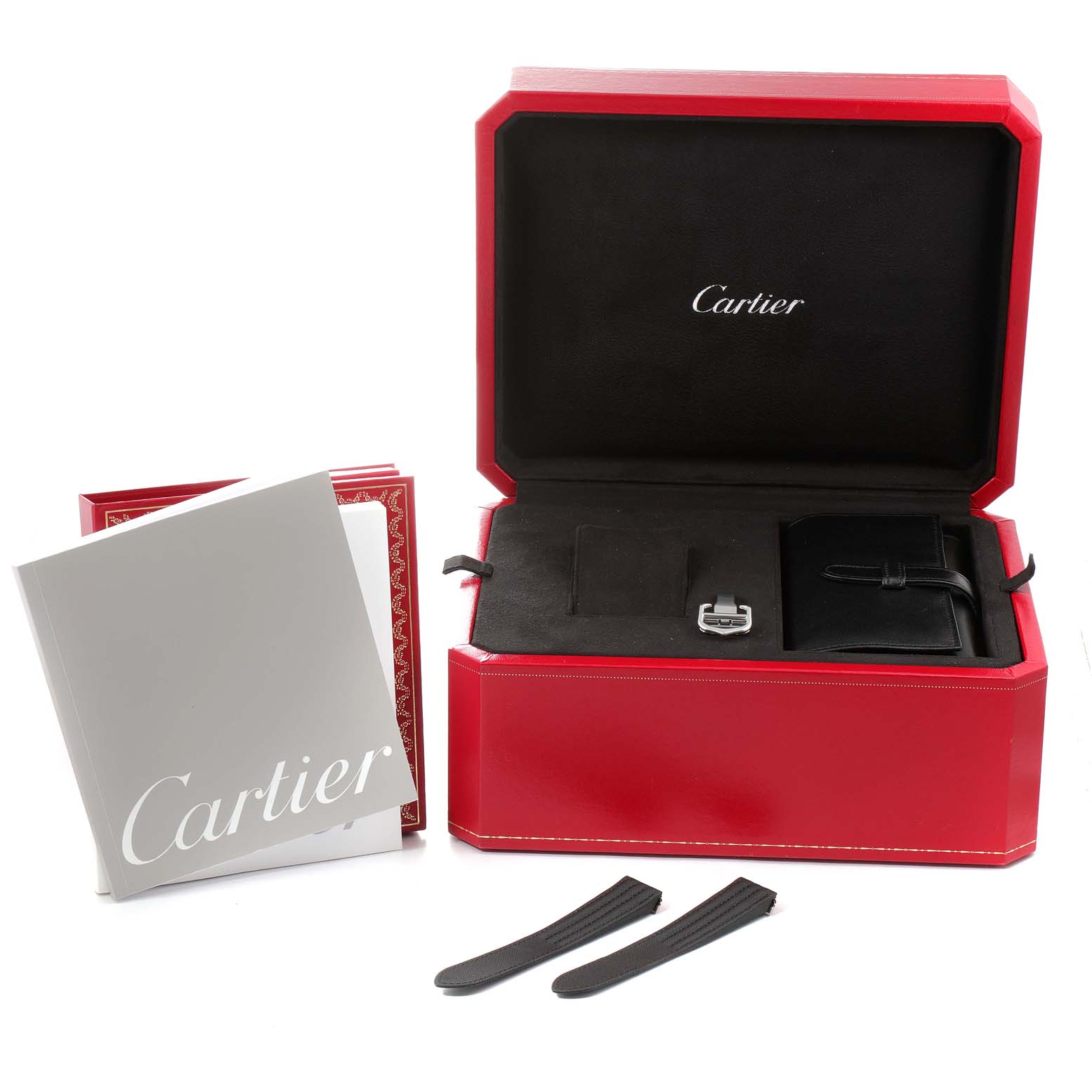 The image shows a Cartier Roadster W62020X6 Men
s Stainless Steel Black Dial W62020X6 Men
s Stainless Steel Black Dial watch box, booklets, a buckle, and extra straps from a top angle.