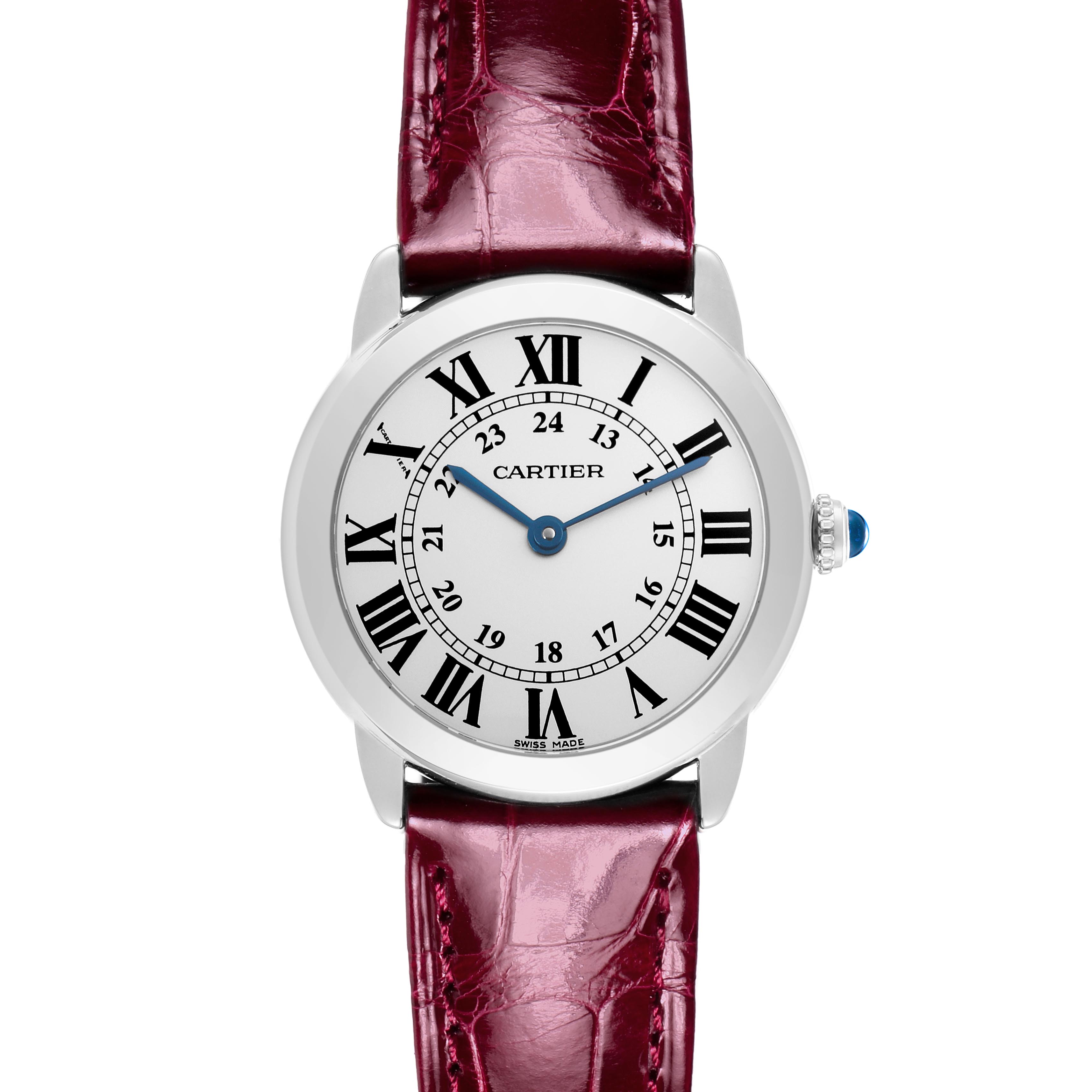 The Cartier Ronde W6700155 Women
s Stainless Steel Silver Dial W6700155 Women
s Stainless Steel Silver Dial watch is shown from a front angle, displaying the face, Roman numerals, blue hands, and a red leather strap.