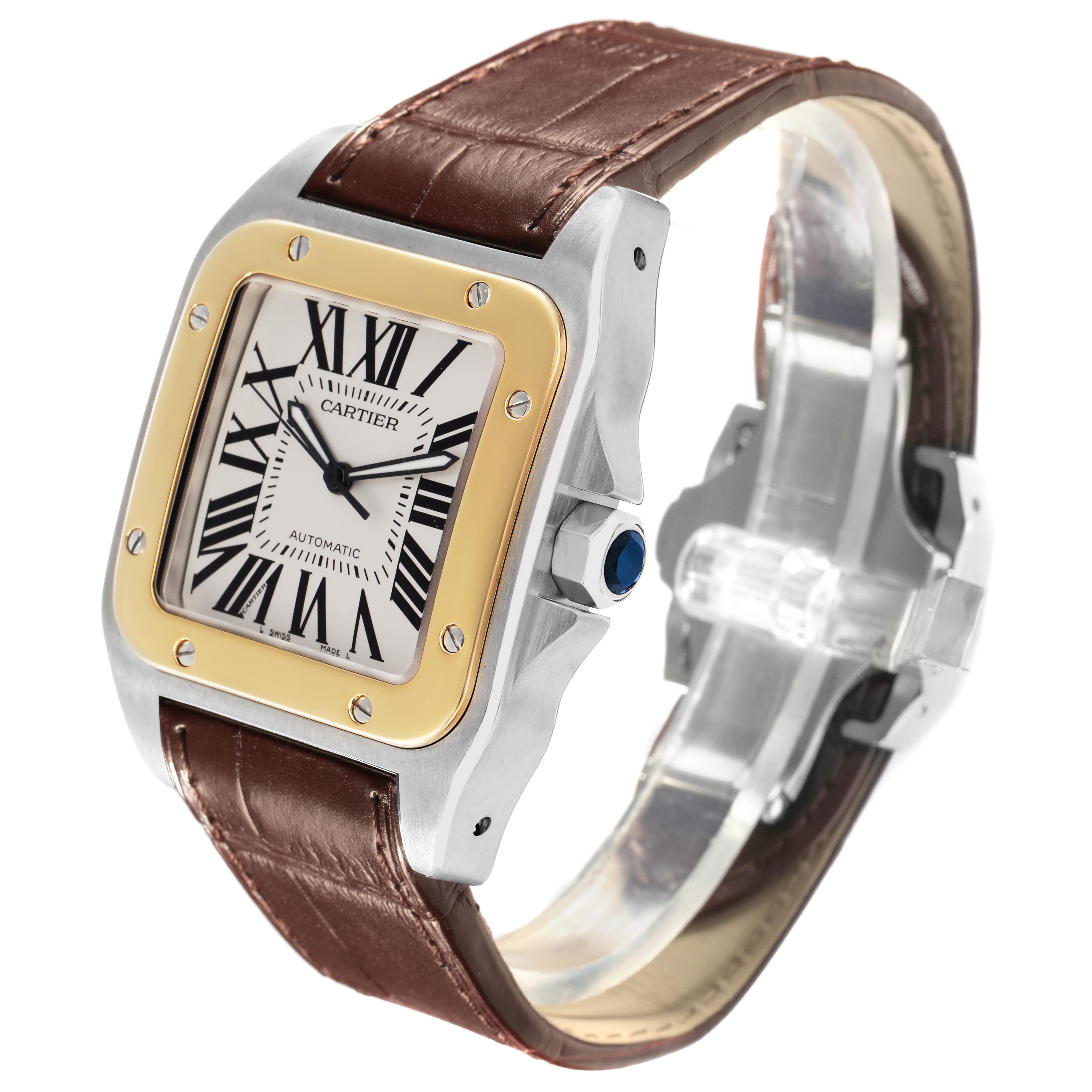 The Cartier Santos W20072X7 Men's Steel and Gold (two tone) Silver Dial W20072X7 Men's Steel and Gold (two tone) Silver Dial watch is angled to show the face, bezel, crown, and brown leather strap.