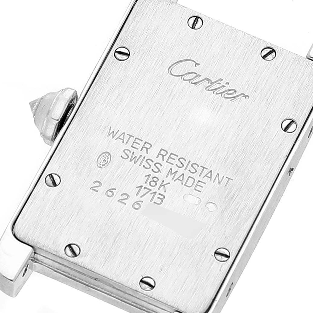 The image shows the back of a Cartier Tank Americaine WB701851 Women's White Gold Silver Dial WB701851 Women's White Gold Silver Dial watch, highlighting its engraved details and screws.