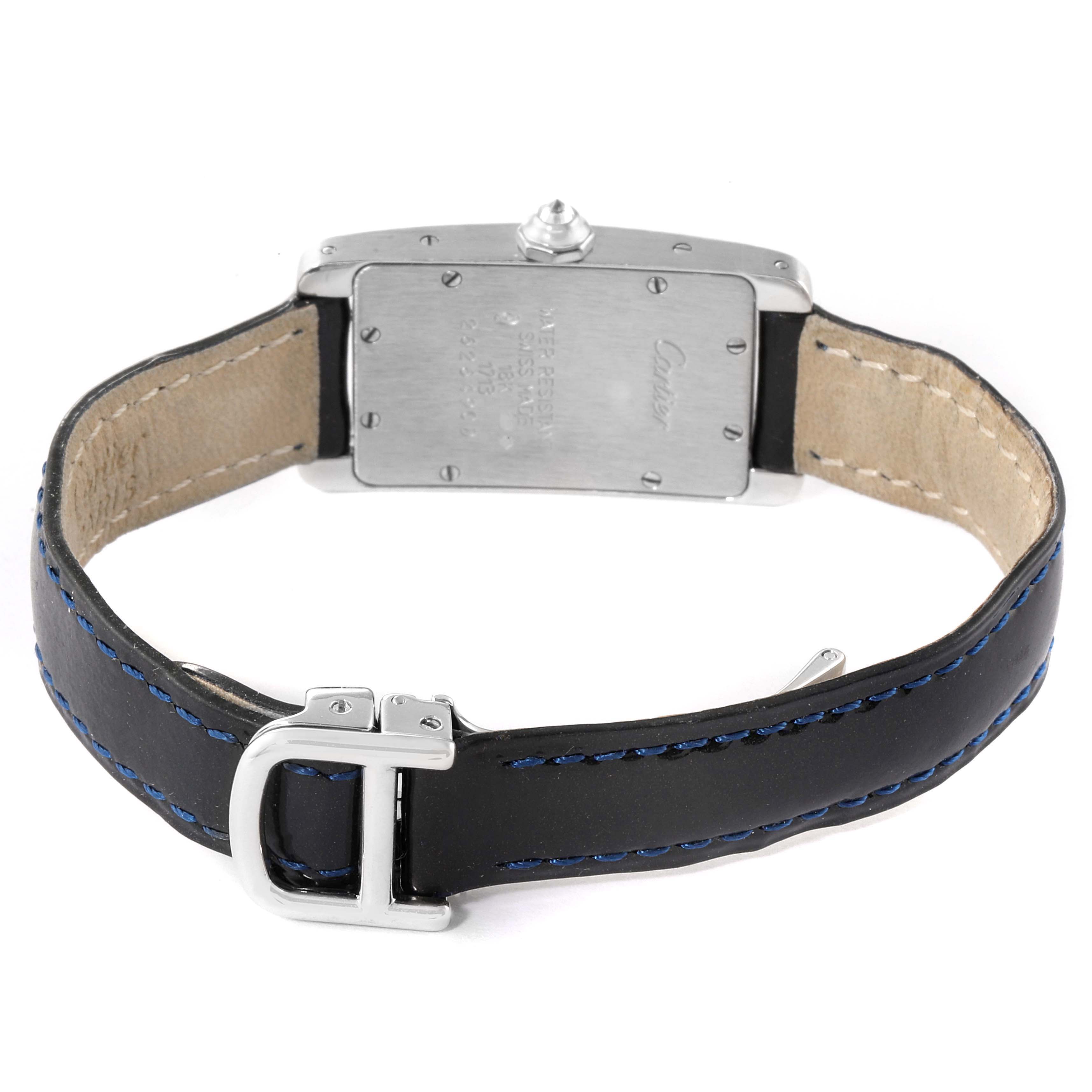 The image shows the back of the Cartier Tank Americaine WB701851 Women's White Gold Silver Dial watch, highlighting the caseback, crown, and leather strap with blue stitching.