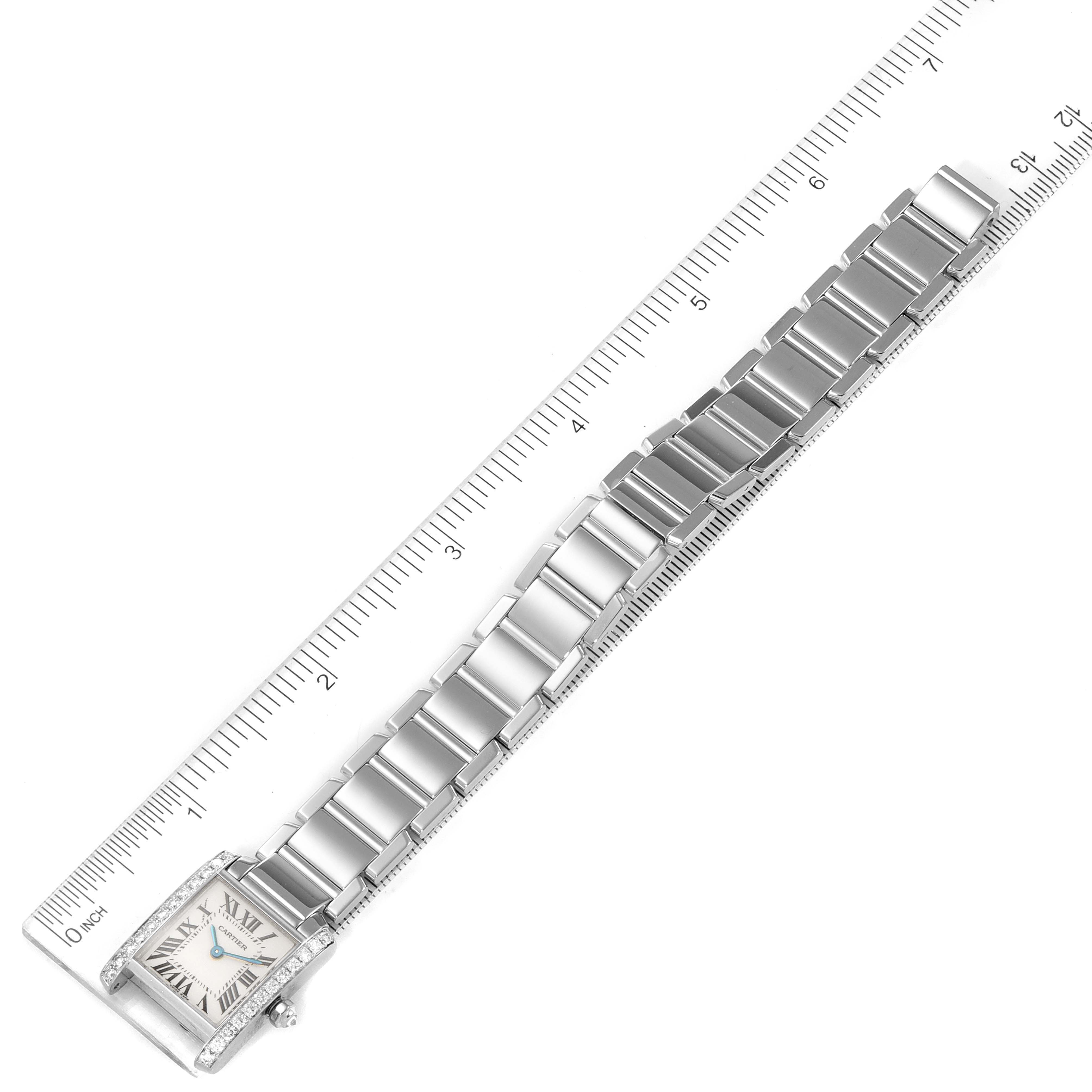 The Cartier Tank Francaise WE1002S3 Women's White Gold Silver Dial WE1002S3 Women's White Gold Silver Dial watch is shown from a top-down angle, including its full bracelet and dial, placed next to a ruler for scale.
