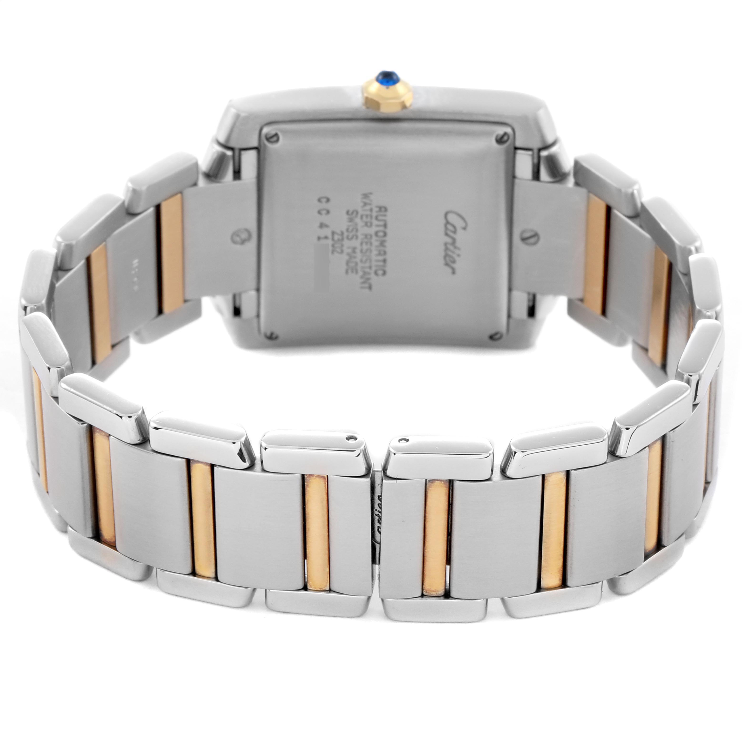 The Cartier Tank Française is shown from the back, highlighting the stainless steel and gold bracelet and case back details.