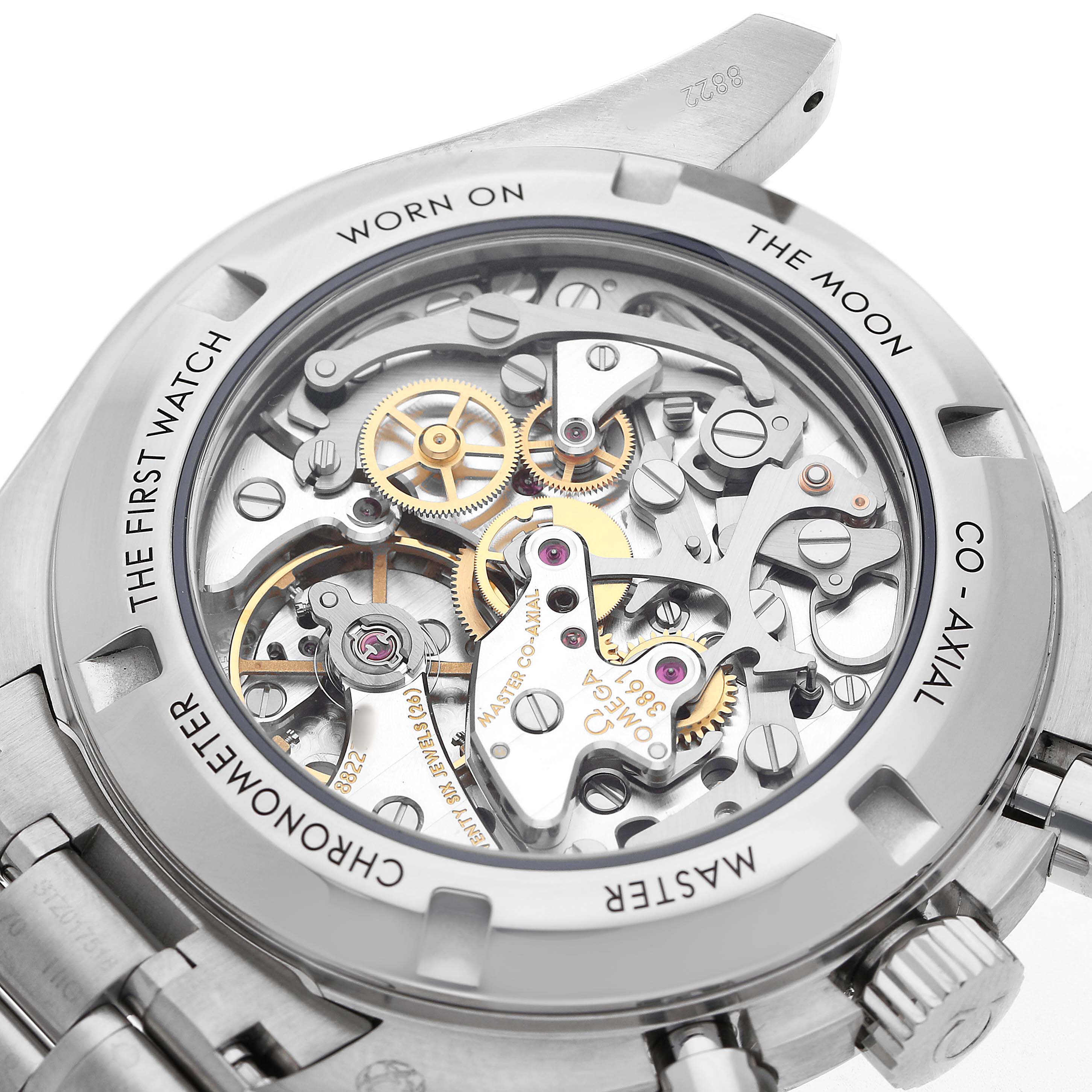 The image shows the back view of an Omega Speedmaster 310.30.42.50.04.001 Men's Stainless Steel White Dial, focusing on its intricate movement and gears.