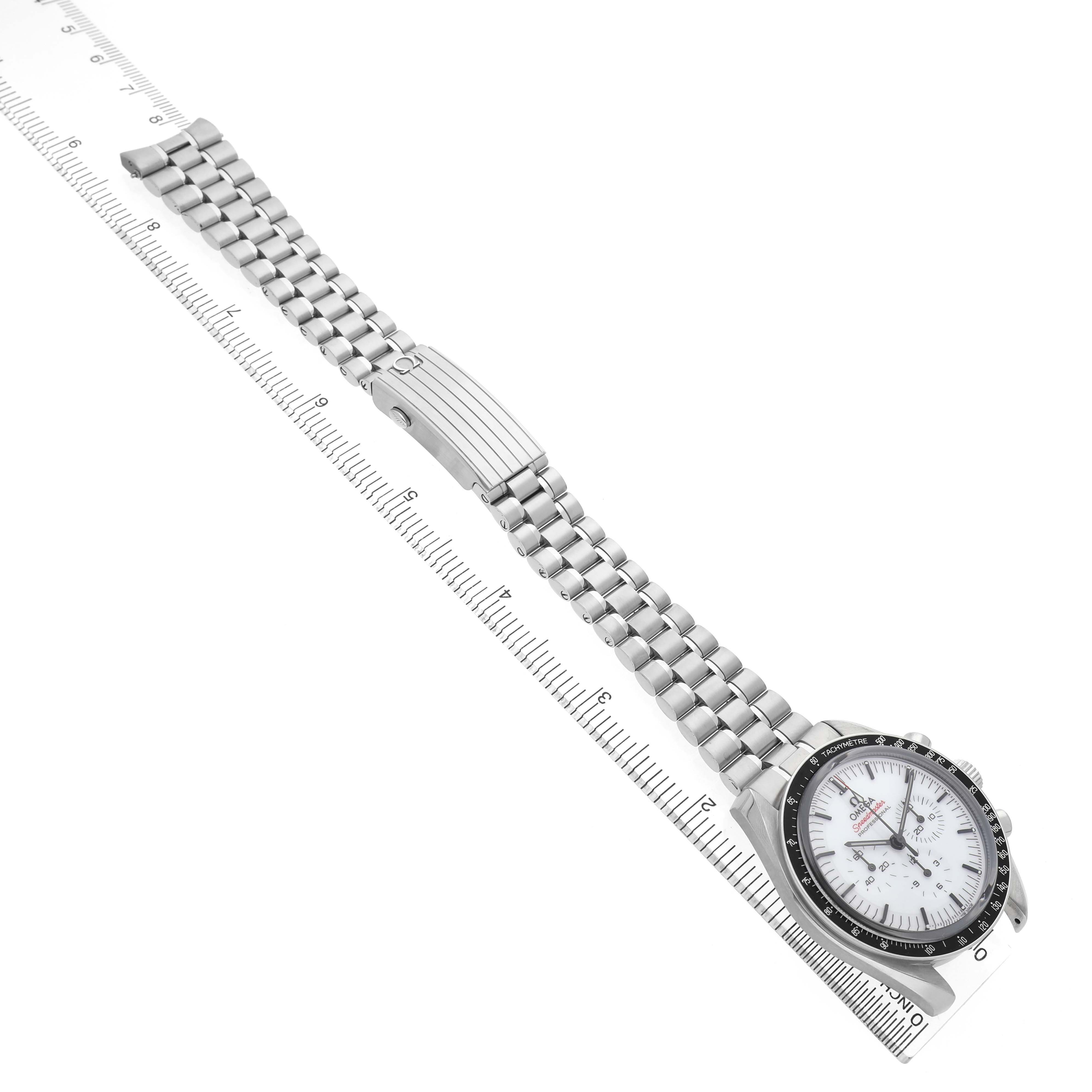 The Omega Speedmaster 310.30.42.50.04.001 Men's Stainless Steel White Dial watch is shown diagonally, displaying its face, clasp, and full metal bracelet alongside a ruler.