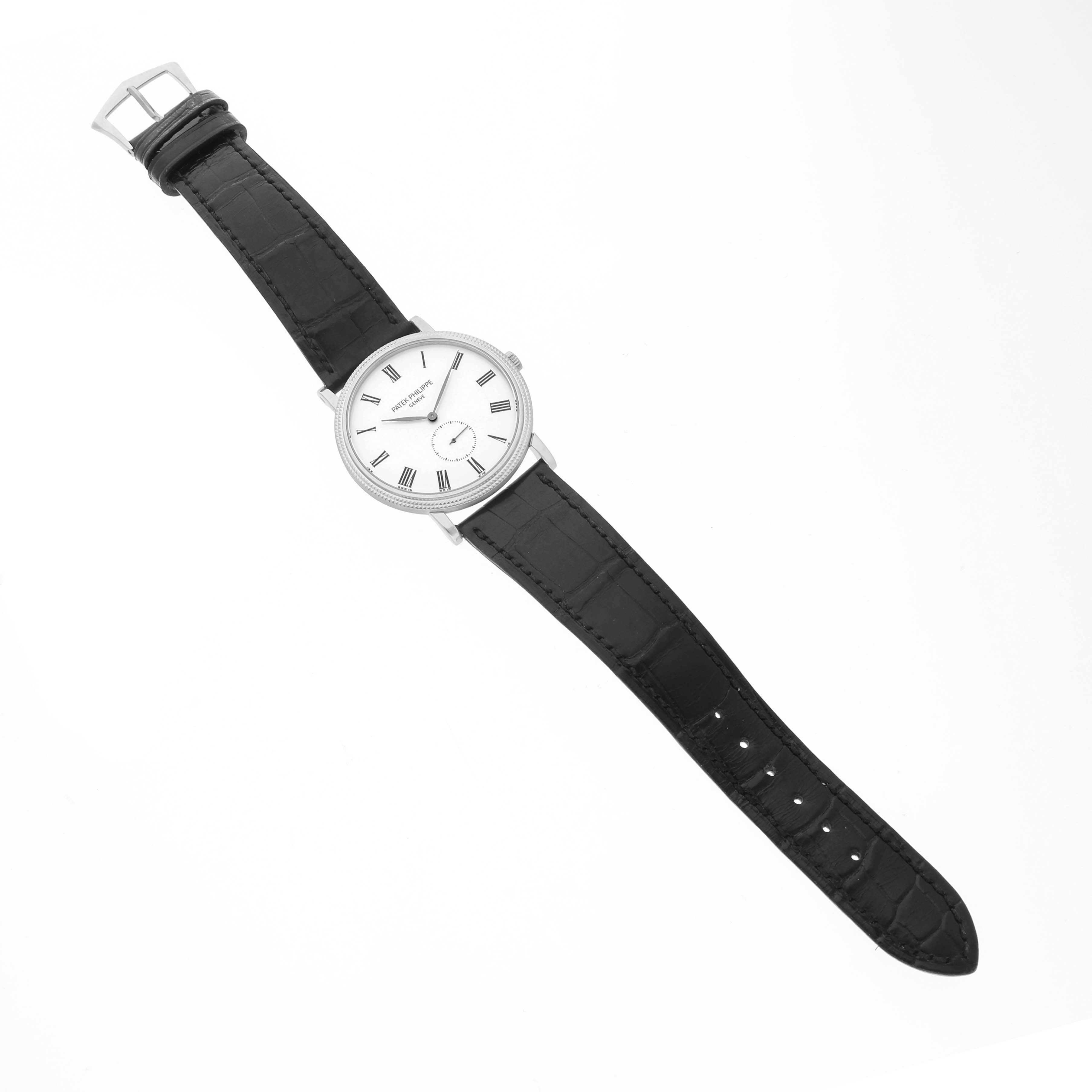 The image shows a Patek Philippe Calatrava 5116 Men's White Gold White Dial watch from a top-down angle, highlighting the dial, case, and black leather strap.
