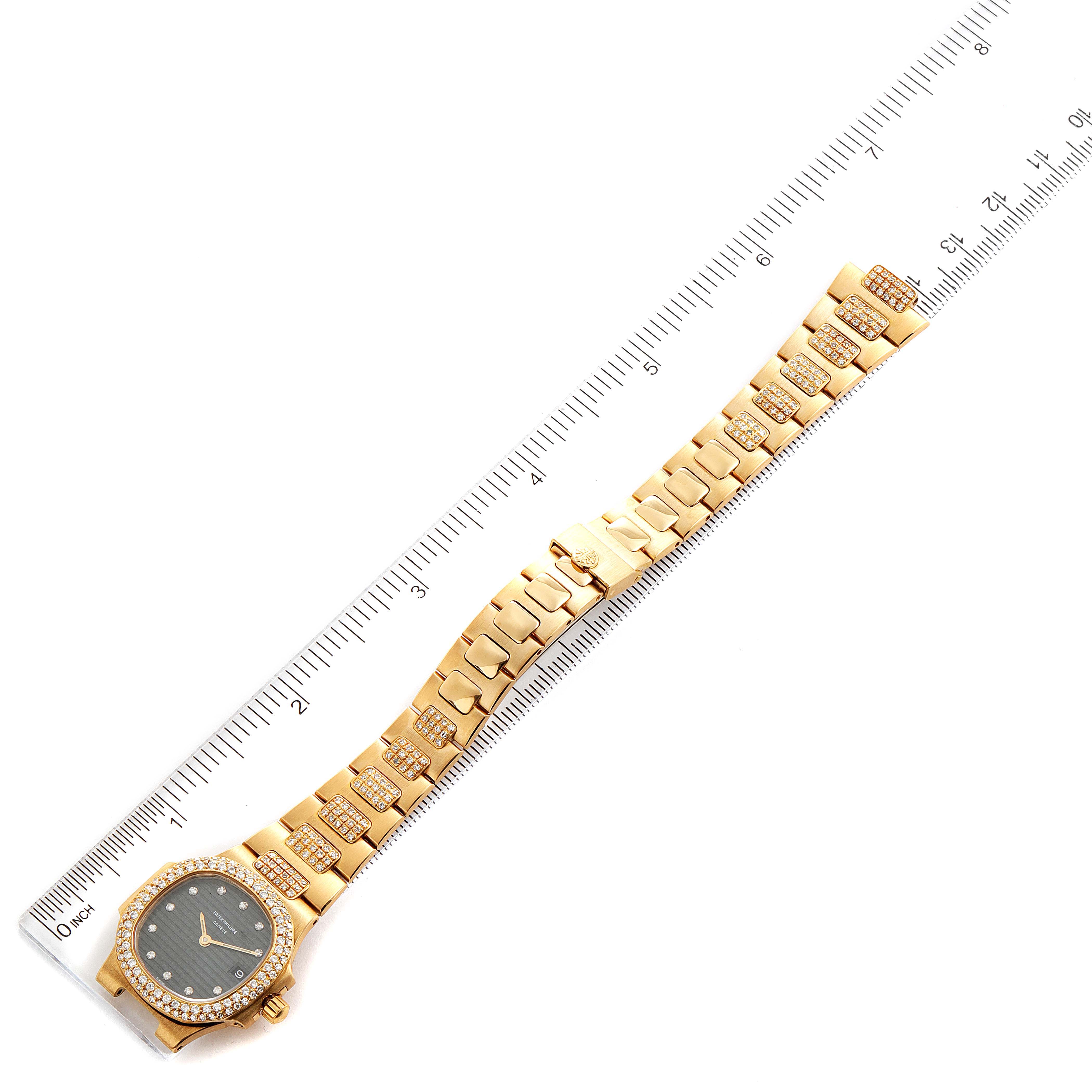 The image shows a Patek Philippe Nautilus 4700/G Women's Yellow Gold Black Dial 4700/G Women's Yellow Gold Black Dial watch, displayed flat with the entire bracelet extended alongside a ruler for measurement.