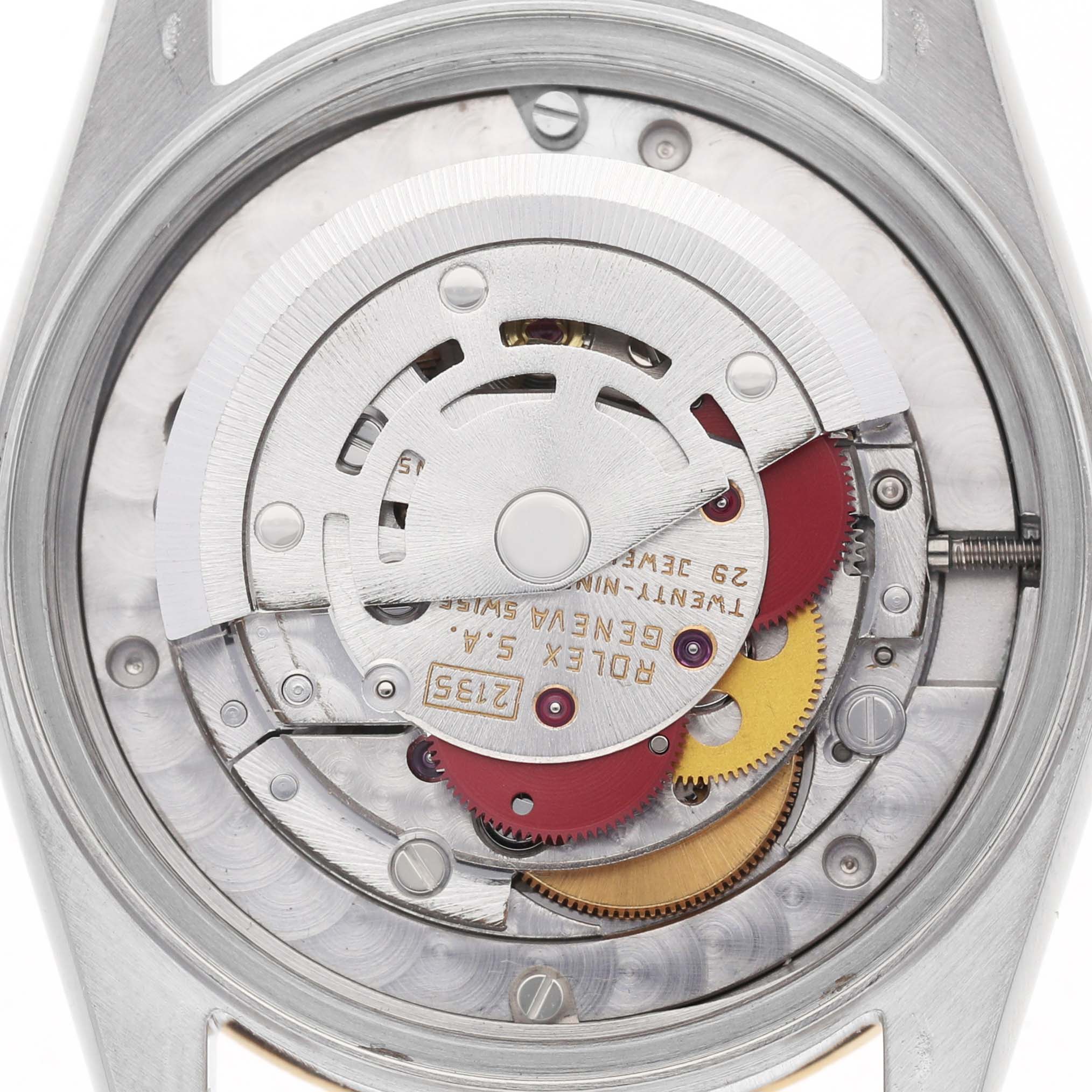 The image shows the movement of a Rolex Datejust 68273 Women's Stainless Steel White Dial watch, viewed from the back, displaying its intricate gears and rotor.