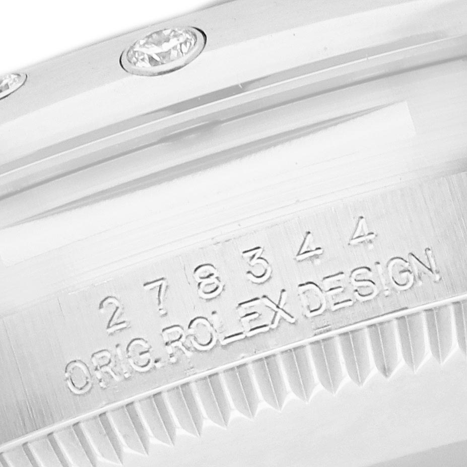 The image shows a close-up of the bezel with diamonds and serial engraving on a Rolex Datejust watch.