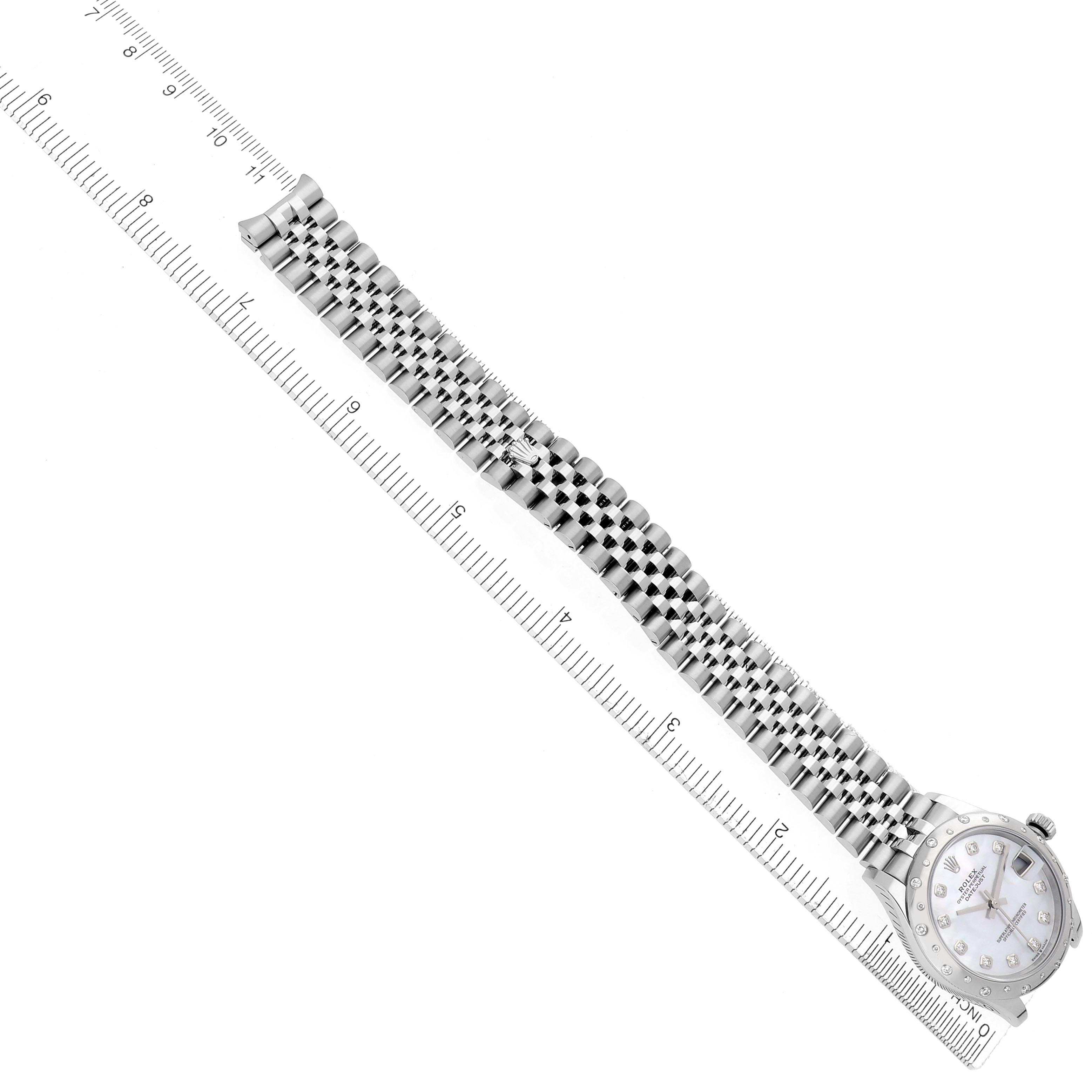 The Rolex Datejust watch is shown at an angled top view, highlighting the bracelet, case, and dial alongside a ruler.
