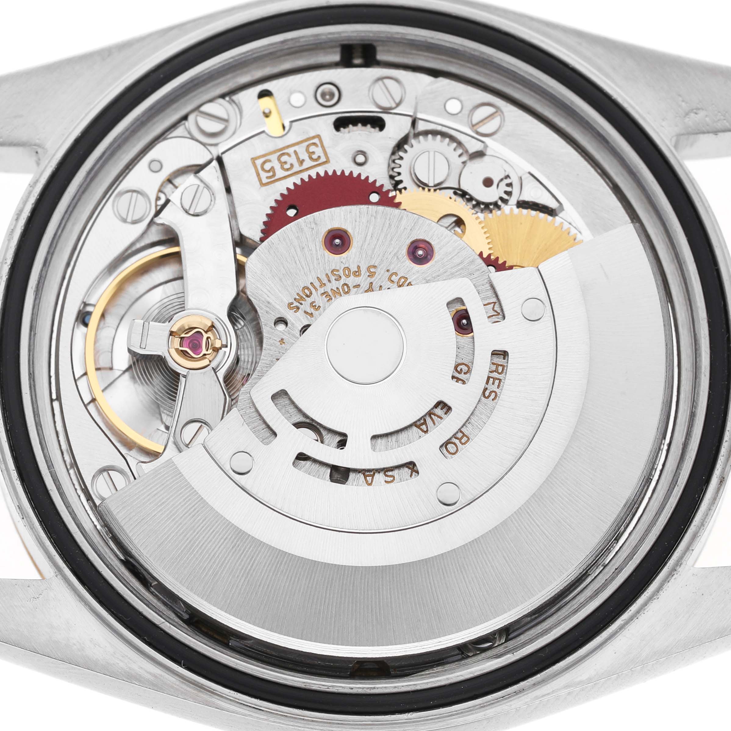 The image shows the movement of a Rolex Datejust 16233 Men's Steel and Gold (two tone) White Dial watch from a rear view, emphasizing the gears and rotor.