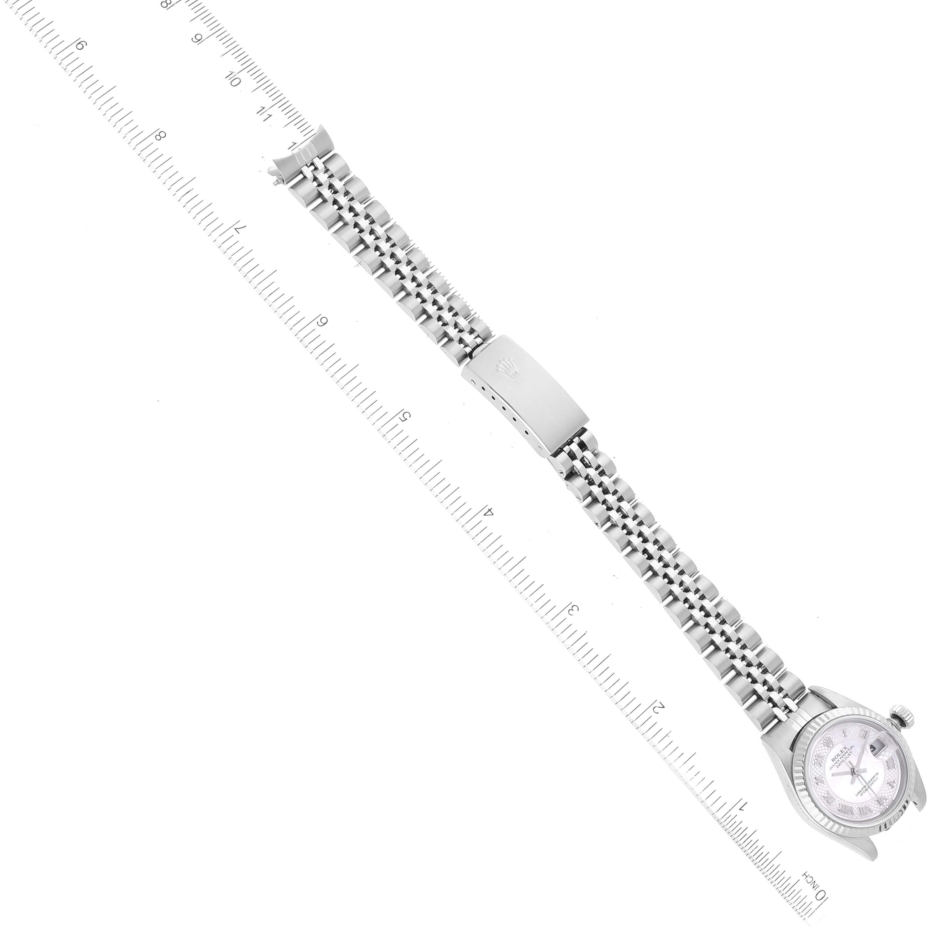 The image shows a Rolex Datejust 79174 Women's Stainless Steel Mother of Pearl Dial 79174 Women's Stainless Steel Mother of Pearl Dial watch laid flat with its band extended, partially measured against a ruler.