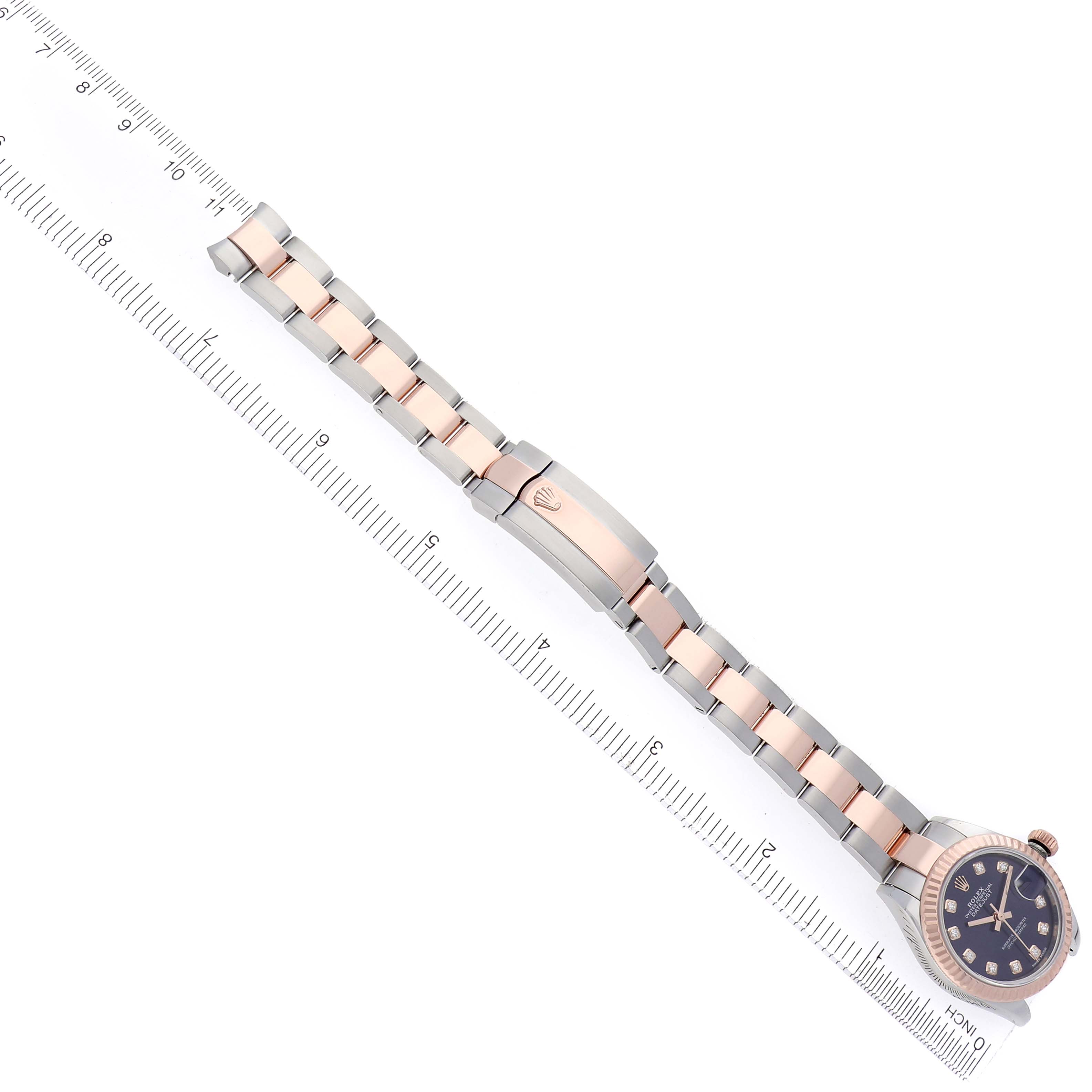The image shows a Rolex Datejust 279171 Women
s Steel and Gold (two tone) Purple Dial 279171 Women
s Steel and Gold (two tone) Purple Dial watch bracelet and clasp at a diagonal angle, alongside a ruler for scale.