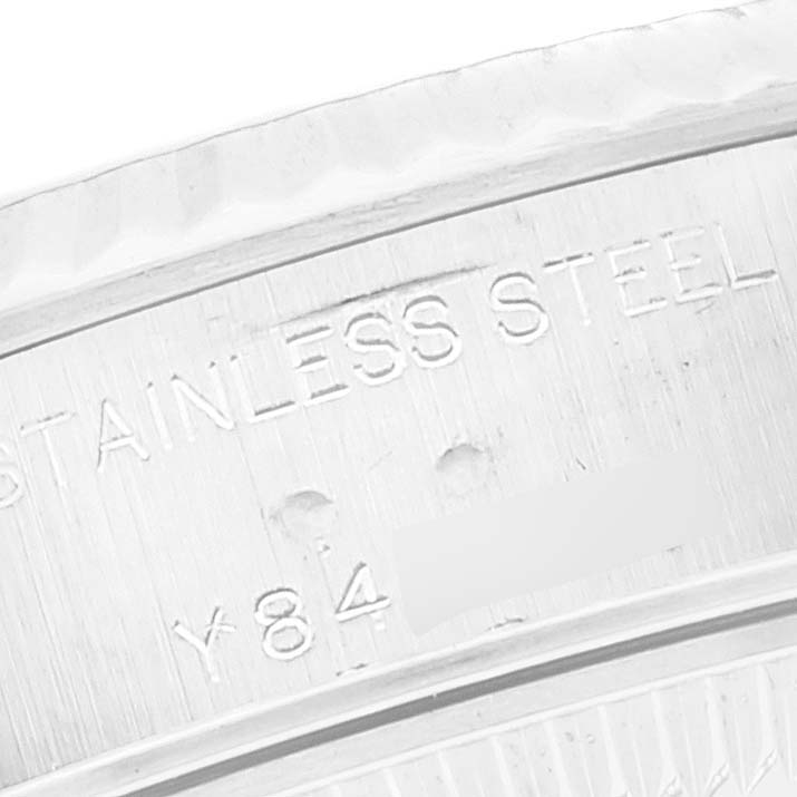 Close-up of the inner rim of a Datejust model by Rolex, showing the engraving "STAINLESS STEEL" and part of a serial number.