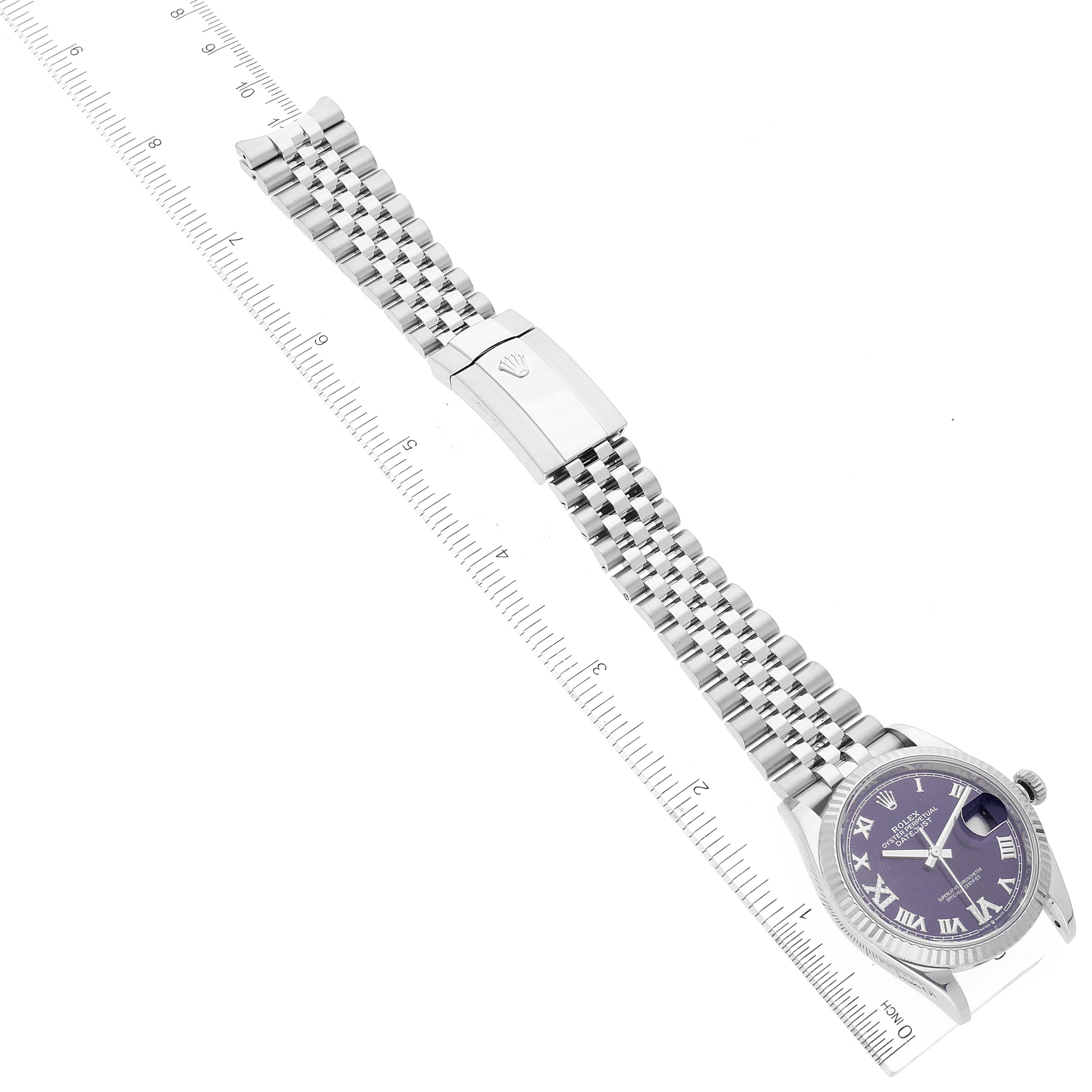 The image shows a Rolex Datejust 126234 Men's Stainless Steel Purple Dial 126234 Men's Stainless Steel Purple Dial watch laid flat with its full bracelet and clasp, positioned next to a ruler for scale.