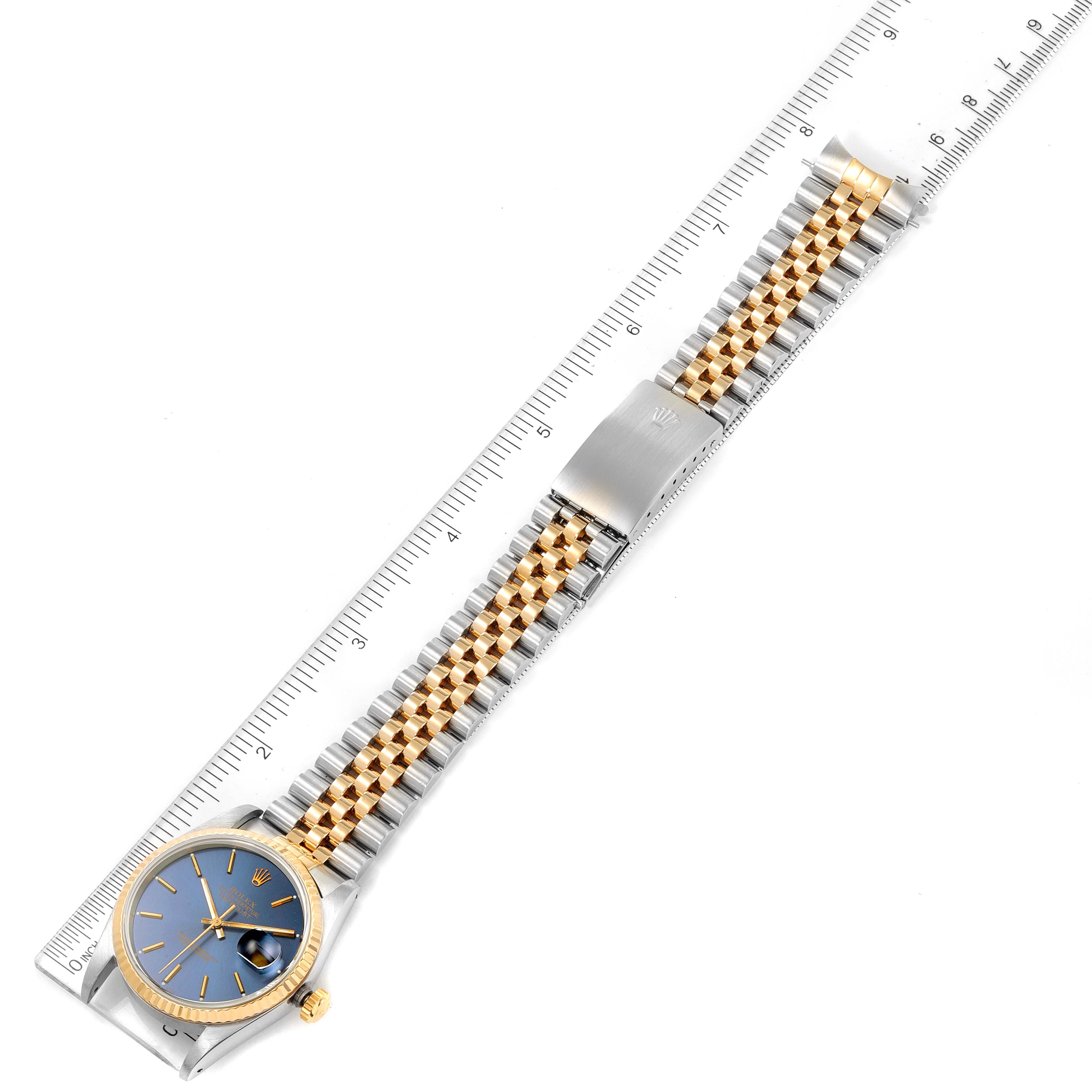 The image shows a top-down view of a Rolex Datejust 16233 Men's Steel and Gold (two tone) Blue Dial 16233 Men's Steel and Gold (two tone) Blue Dial watch with a two-tone bracelet and a blue dial, alongside a ruler for scale.
