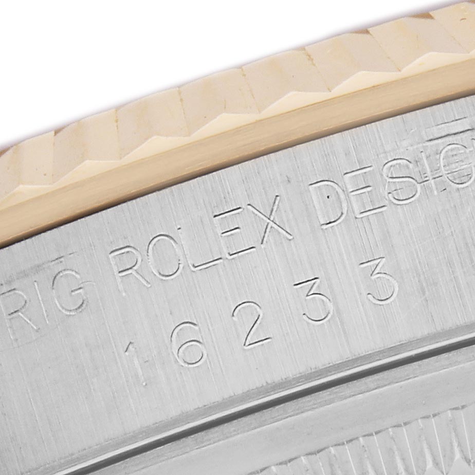 The image shows the side view of a Rolex Datejust 16233 Men
s Steel and Gold (two tone) Mother of Pearl Dial 16233 Men
s Steel and Gold (two tone) Mother of Pearl Dial watch, highlighting the engraved case back and part of the fluted bezel.