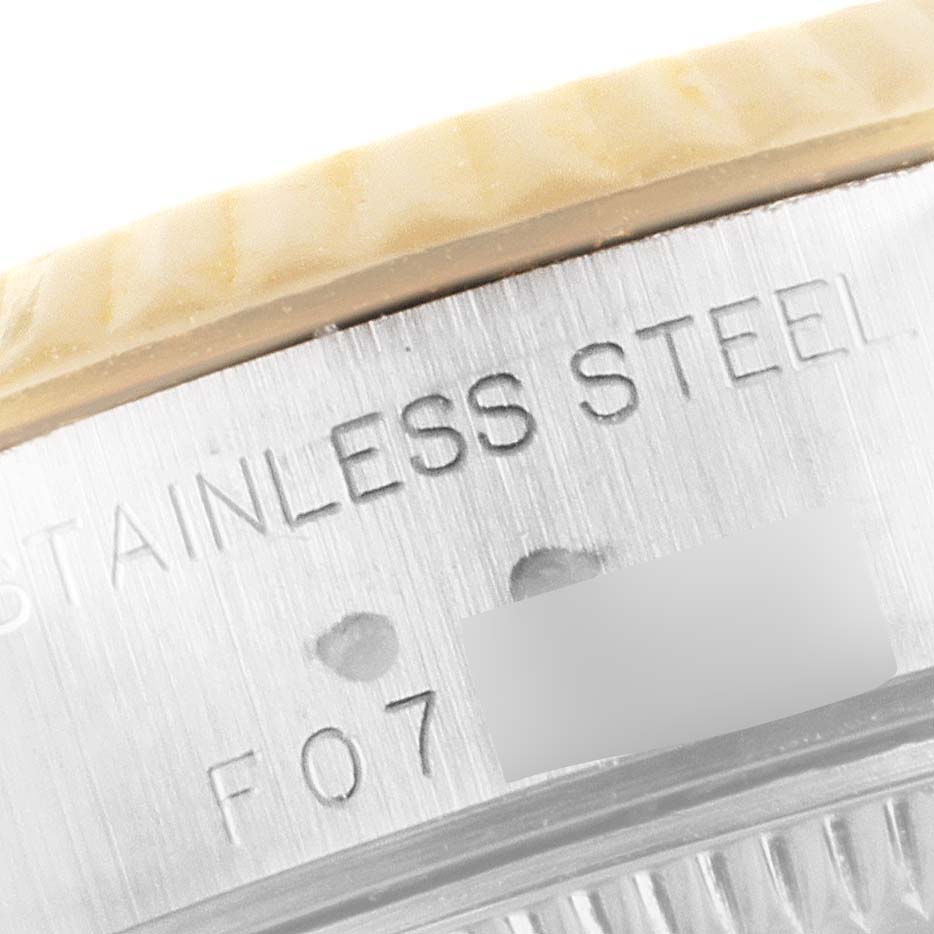 The image shows a close-up of the edge of a Rolex Datejust 79173 Women's Steel and Gold (two tone) Mother of Pearl Dial 79173 Women's Steel and Gold (two tone) Mother of Pearl Dial watch case, highlighting the "STAINLESS STEEL" engraving.