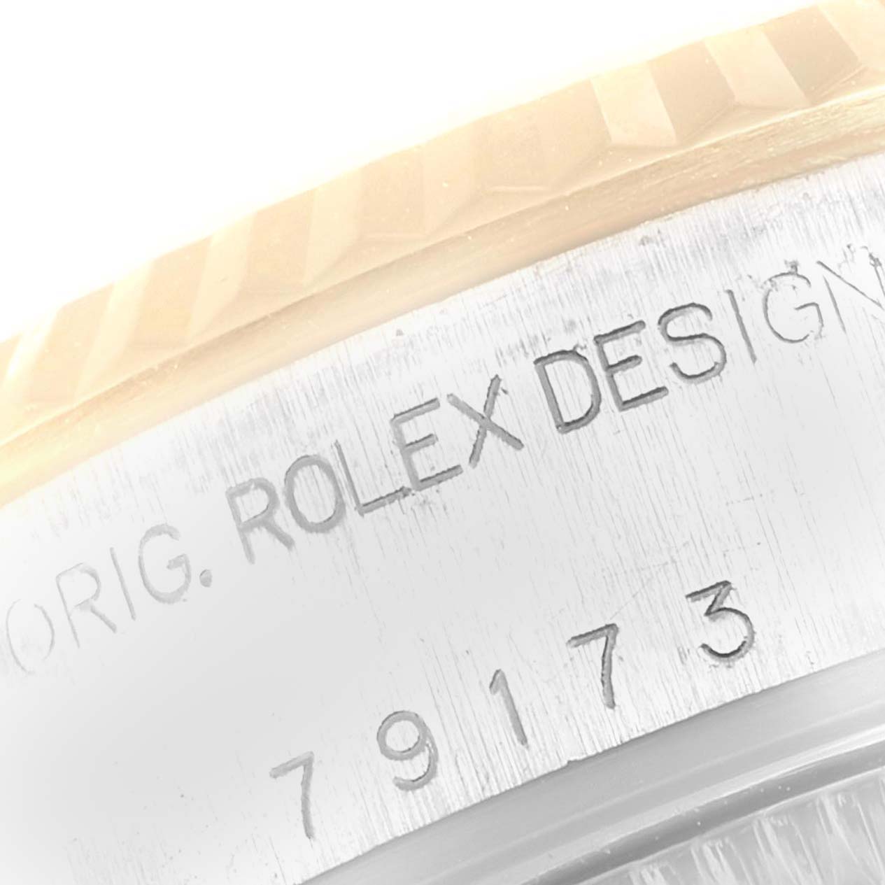 This image shows a close-up of the case side and bezel of a Rolex Datejust 79173 Women
s Steel and Gold (two tone) Grey Dial 79173 Women
s Steel and Gold (two tone) Grey Dial watch, displaying the "ROLEX DESIGN" engraving.