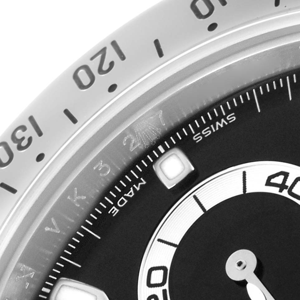 The image shows a close-up of the bezel and part of the dial on a Rolex Daytona 116520 Men's Stainless Steel Black Dial 116520 Men's Stainless Steel Black Dial watch.