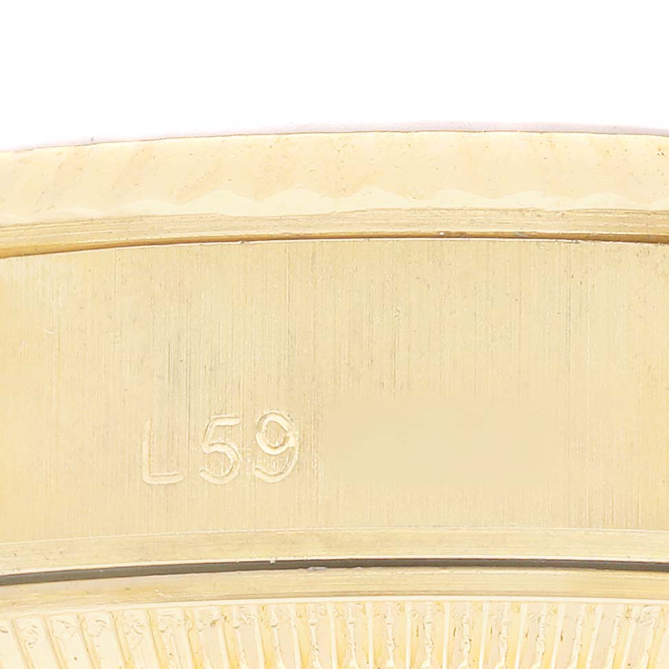 The image shows a close-up of the side of a Rolex President 69178 Women's Yellow Gold Silver Dial watch, focusing on an engraved serial number.