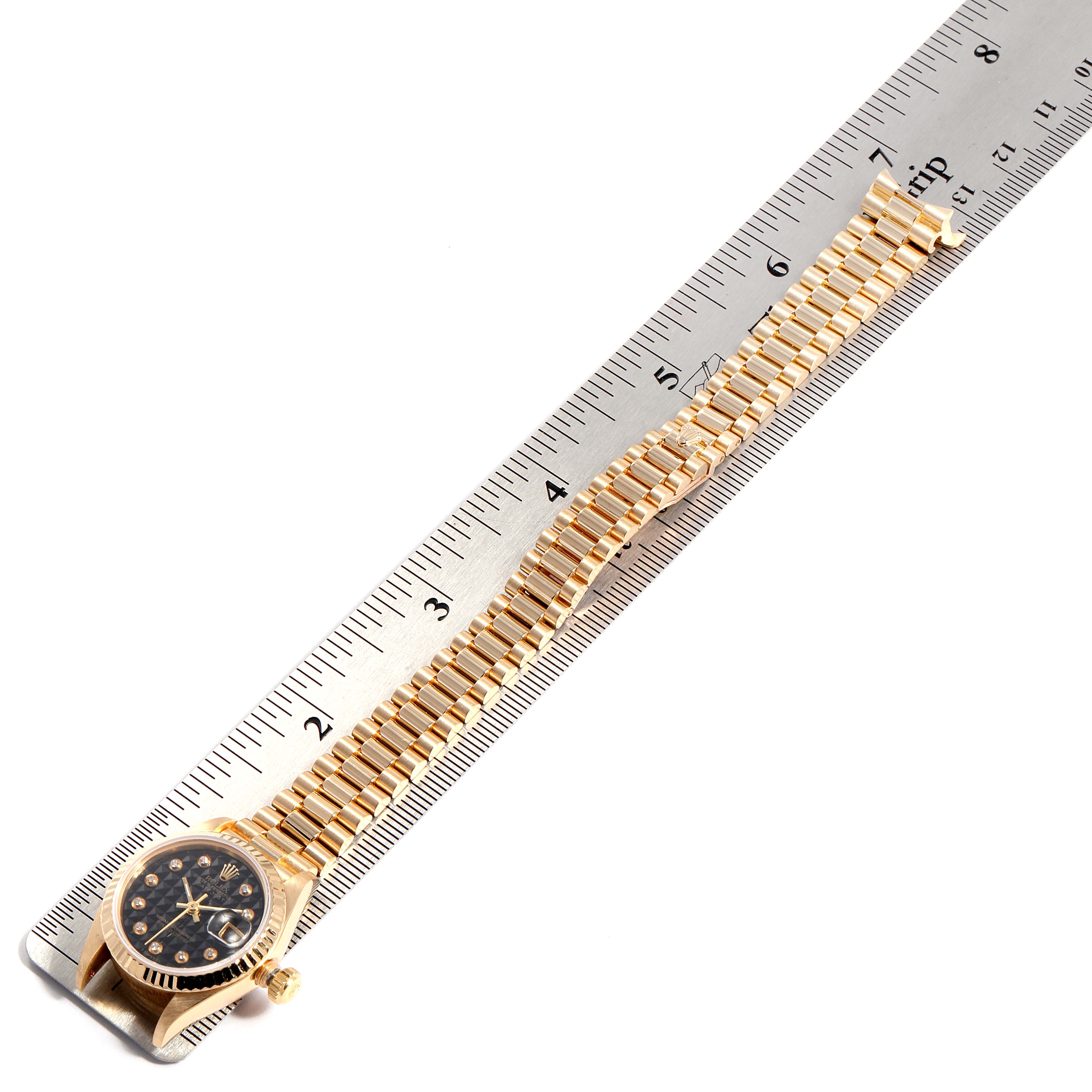 The image shows a Rolex President 69178 Women's Yellow Gold Black Dial 69178 Women's Yellow Gold Black Dial model watch laid flat next to a ruler, displaying the watch face and full bracelet.