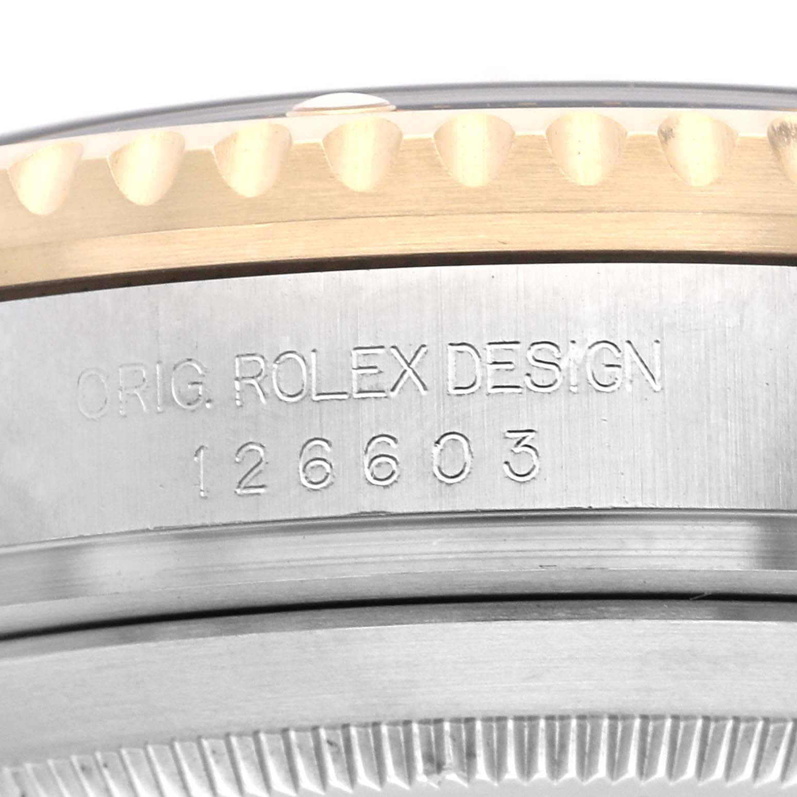 The image shows a close-up of the side of a Rolex Sea-Dweller 126603 Men
s Steel and Gold (two tone) Black Dial 126603 Men
s Steel and Gold (two tone) Black Dial model, focusing on the engraved design number and part of the bezel.