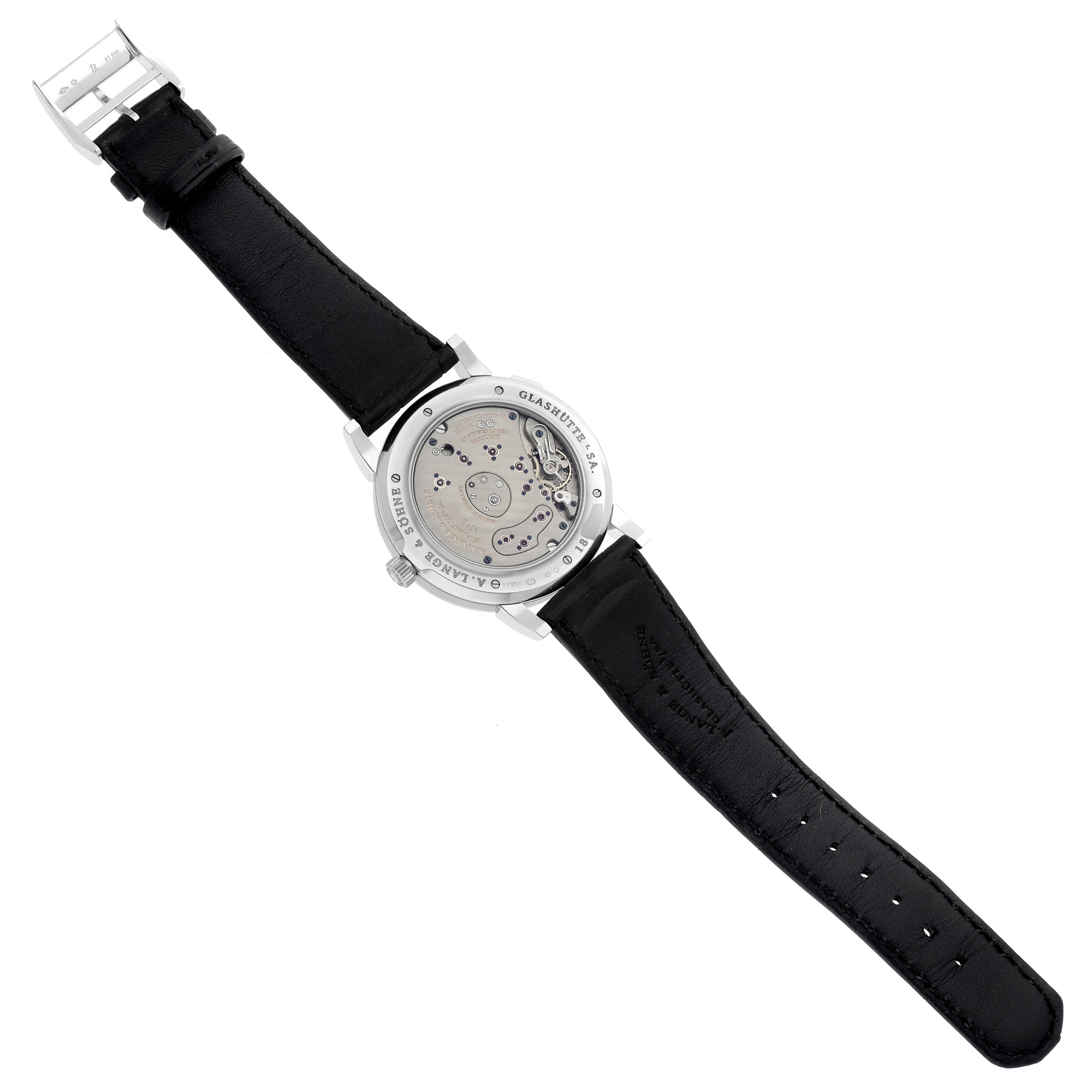 The image shows the A. Lange & Sohne Lange 1 115.026 Men's Platinum Silver Dial watch from the back, highlighting the movement and leather strap.