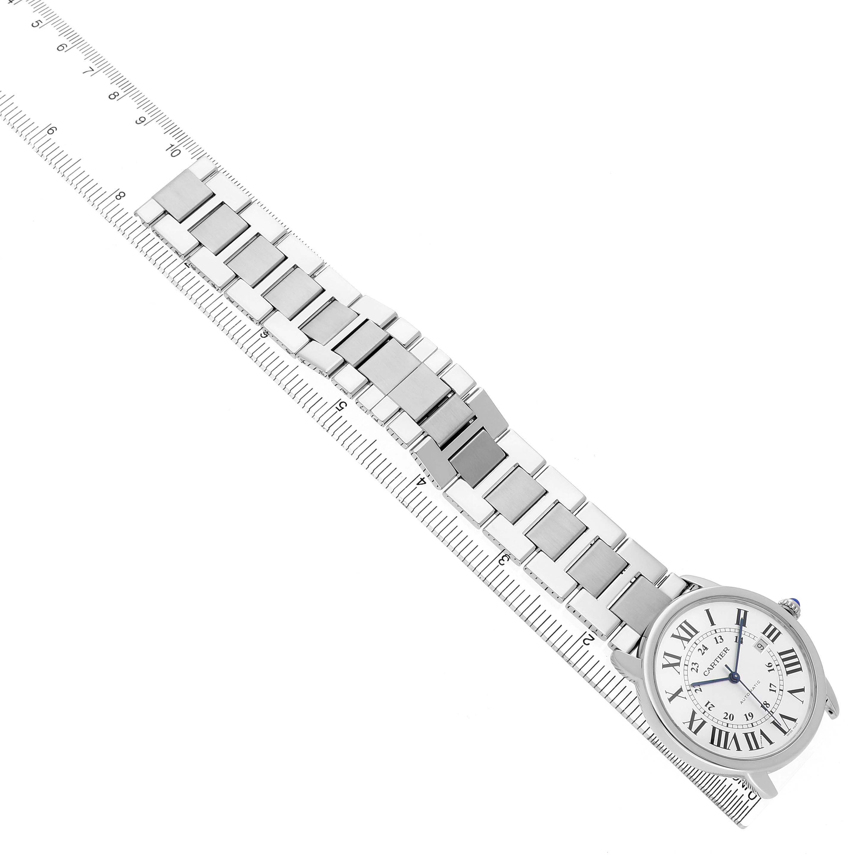 The Cartier Ronde W6701011 Men's Stainless Steel Silver Dial watch is shown from a top-down angle, displaying the face and full metal bracelet aligned with a ruler.