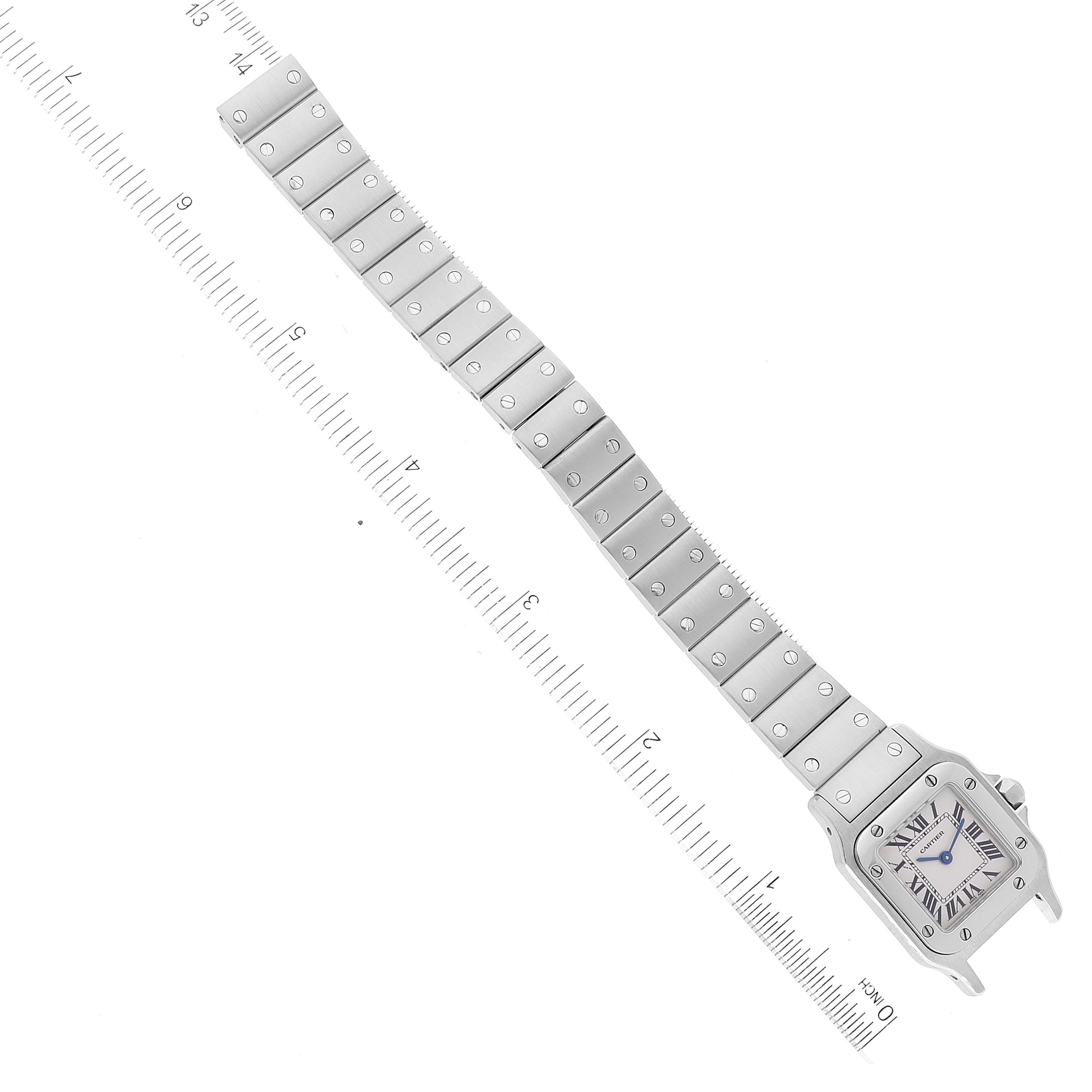 The image shows a top view of a Cartier Santos W20056D6 Women's Stainless Steel Silver Dial W20056D6 Women's Stainless Steel Silver Dial watch, displaying its face and full metal bracelet alongside a measuring scale.
