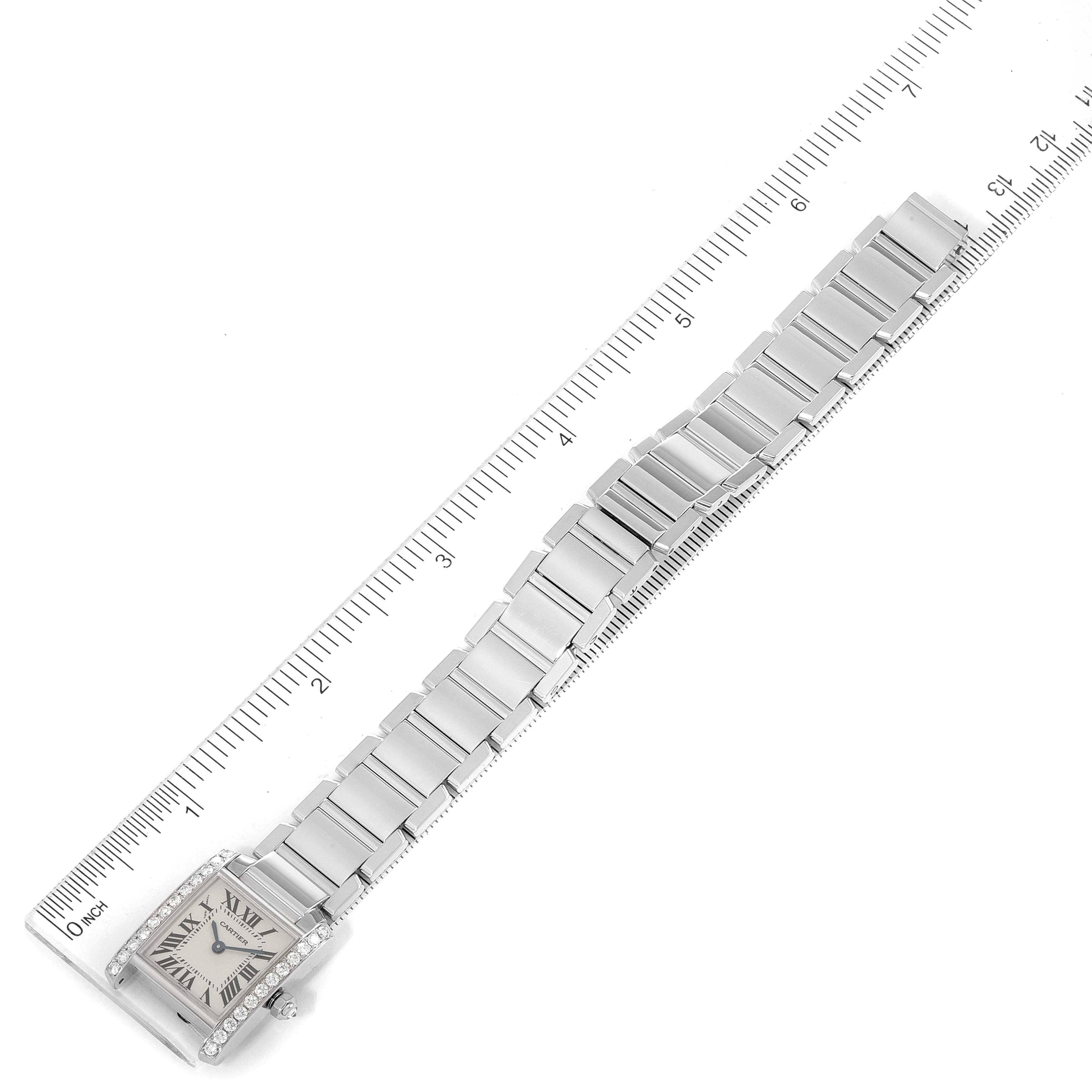 The Cartier Tank Francaise WE1002S3 Women's White Gold Silver Dial WE1002S3 Women's White Gold Silver Dial watch is shown laid flat next to a ruler, displaying its band and rectangular face.
