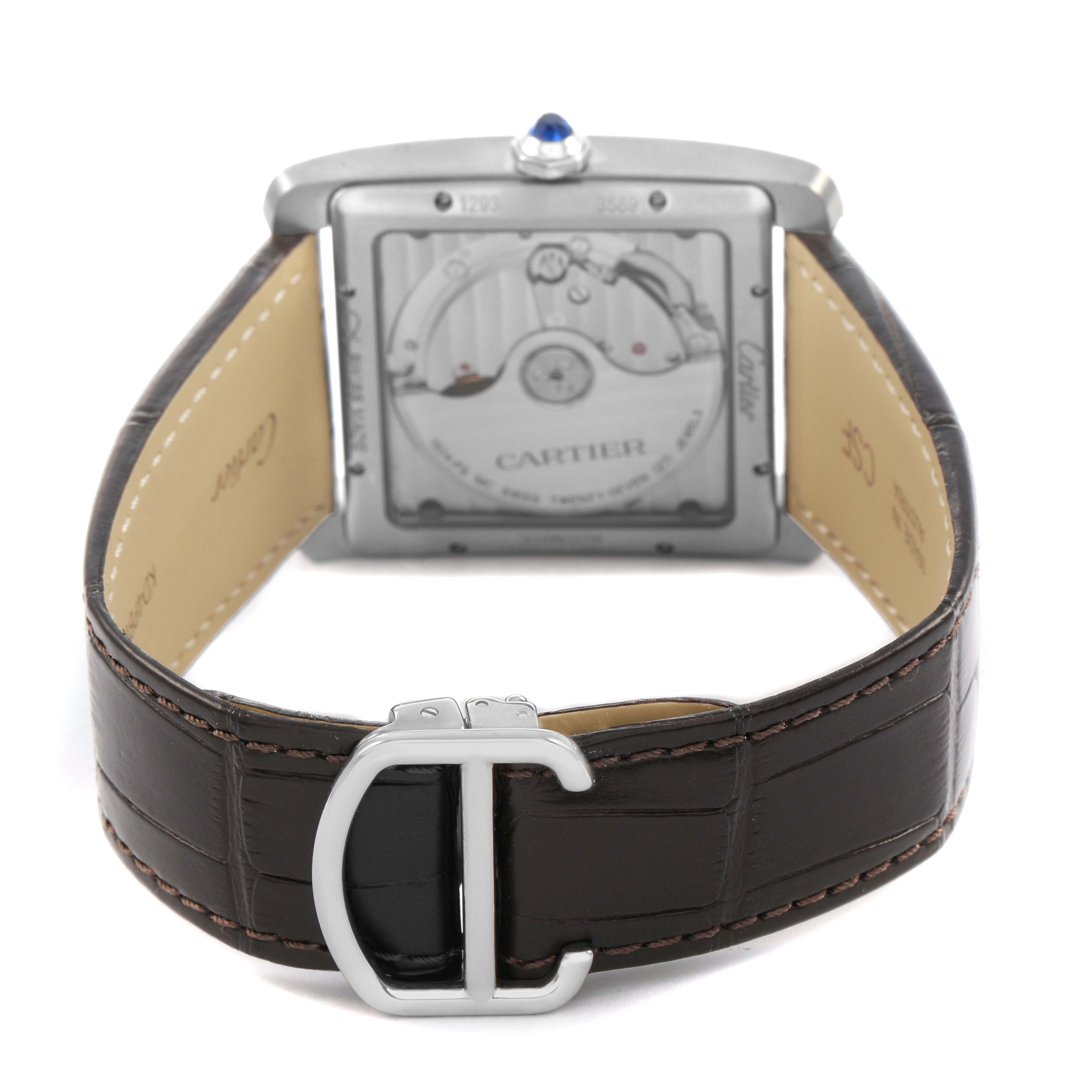 The Cartier Tank MC W5330003 Men's Stainless Steel Black Dial watch is shown from the back, detailing the movement and leather strap with a metal clasp.