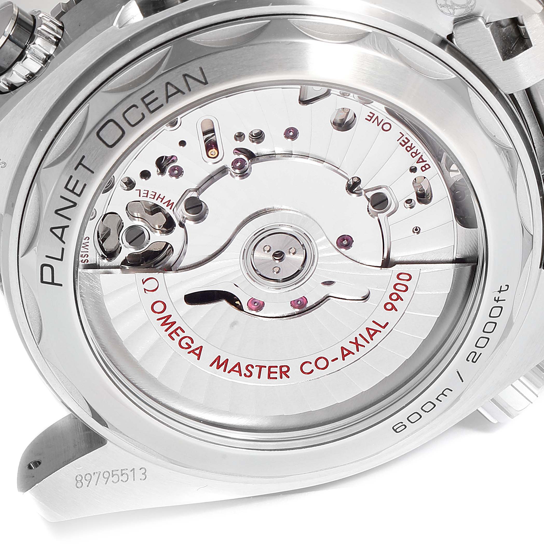 The image shows a close-up view of the Omega Planet Ocean 215.30.46.51.01.001 Men
s Stainless Steel Black Dial 215.30.46.51.01.001 Men
s Stainless Steel Black Dial
s transparent case back, revealing the Co-Axial 9900 movement.