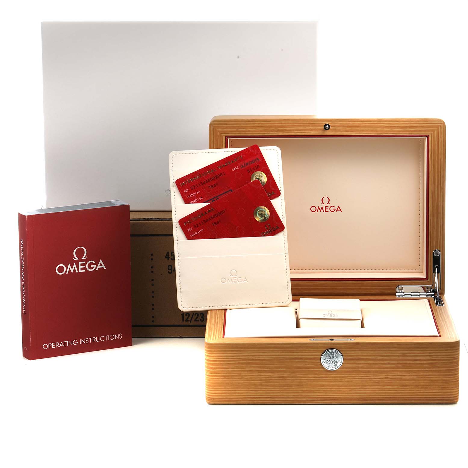 The image shows an Omega Speedmaster 321.13.44.50.02.001 Men's Stainless Steel Silver Dial watch box, warranty cards, instructions, and a cardholder from a front angle.
