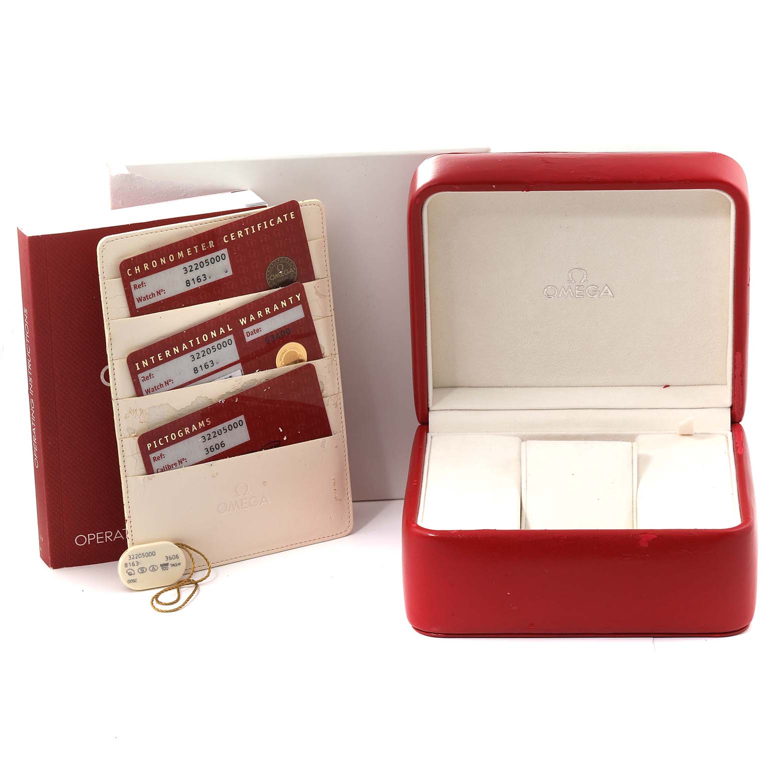 The image shows an Omega Speedmaster 3220.50.00 Men
s Stainless Steel Black Dial 3220.50.00 Men
s Stainless Steel Black Dial watch box set at an angle, including the warranty cards, operation manual, and empty display case.