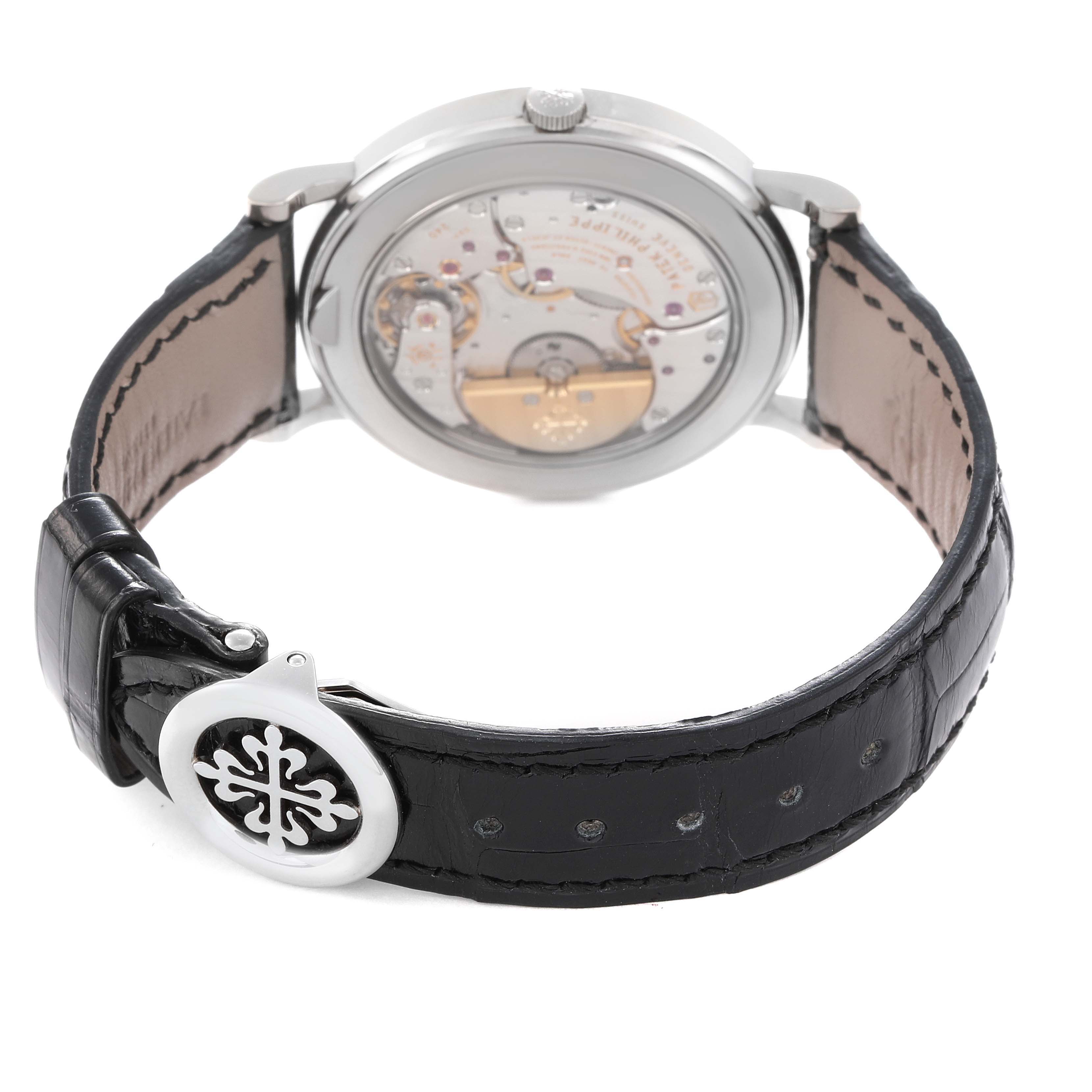 The image shows the back view of a Patek Philippe Complications 5139G Men's White Gold Black Dial 5139G Men's White Gold Black Dial watch, highlighting its movement and leather strap with clasp.