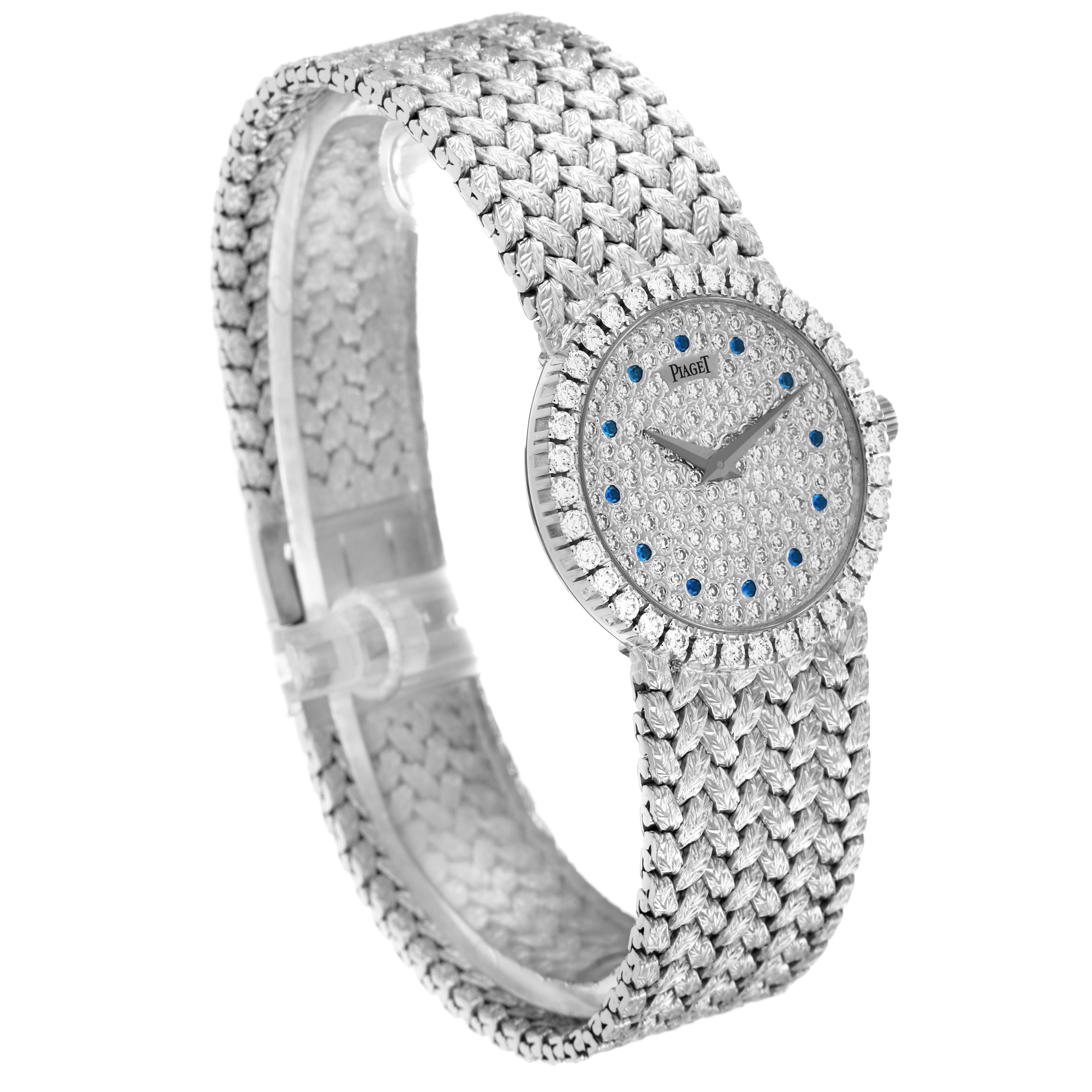 The Piaget 9706D2 Women
s White Gold Silver Dial 9706D2 Women
s White Gold Silver Dial Tradition 9706D2 watch is shown at an angle displaying its diamond-studded face, sapphire markers, and woven bracelet.