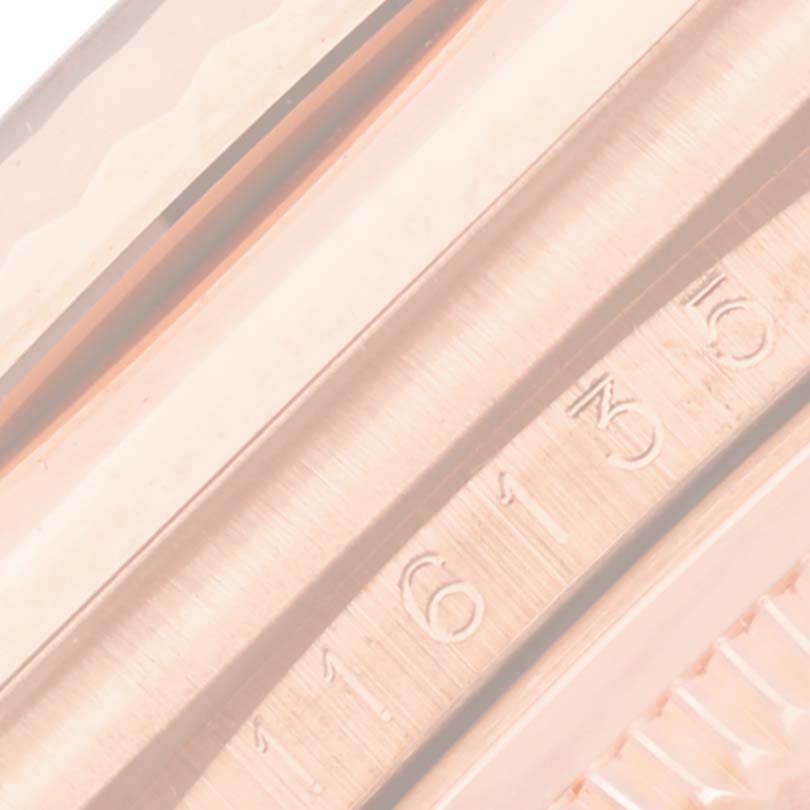 The image shows a close-up of the Rolex Datejust 116135 Mens Rose Gold Pink Dials fluted bezel and part of the serial engraving on the watch case.