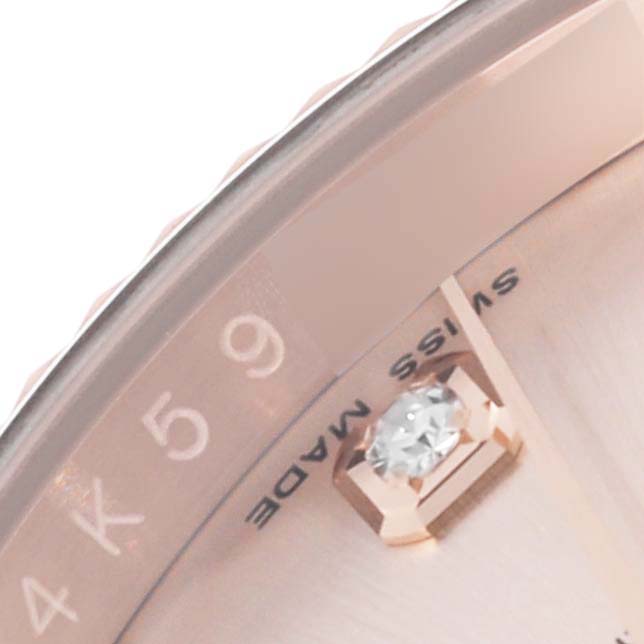 The image shows a close-up of the dial edge, diamond hour marker, and partial text on a Rolex Datejust 116135 Mens Rose Gold Pink Dial watch.