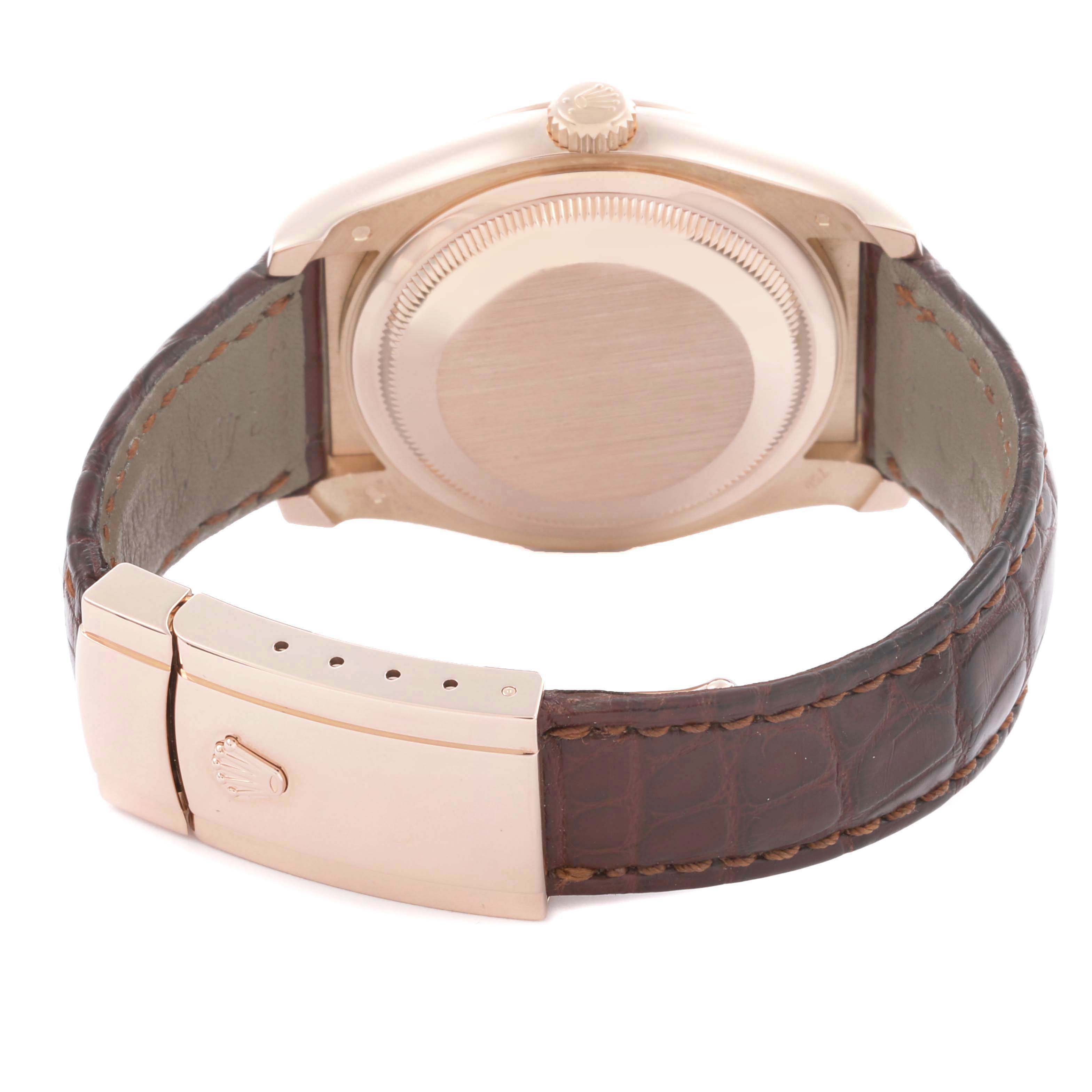 The Rolex Datejust 116135 Mens Rose Gold Pink Dial watch is shown from the back, highlighting the case, crown, and brown leather strap with a clasp.